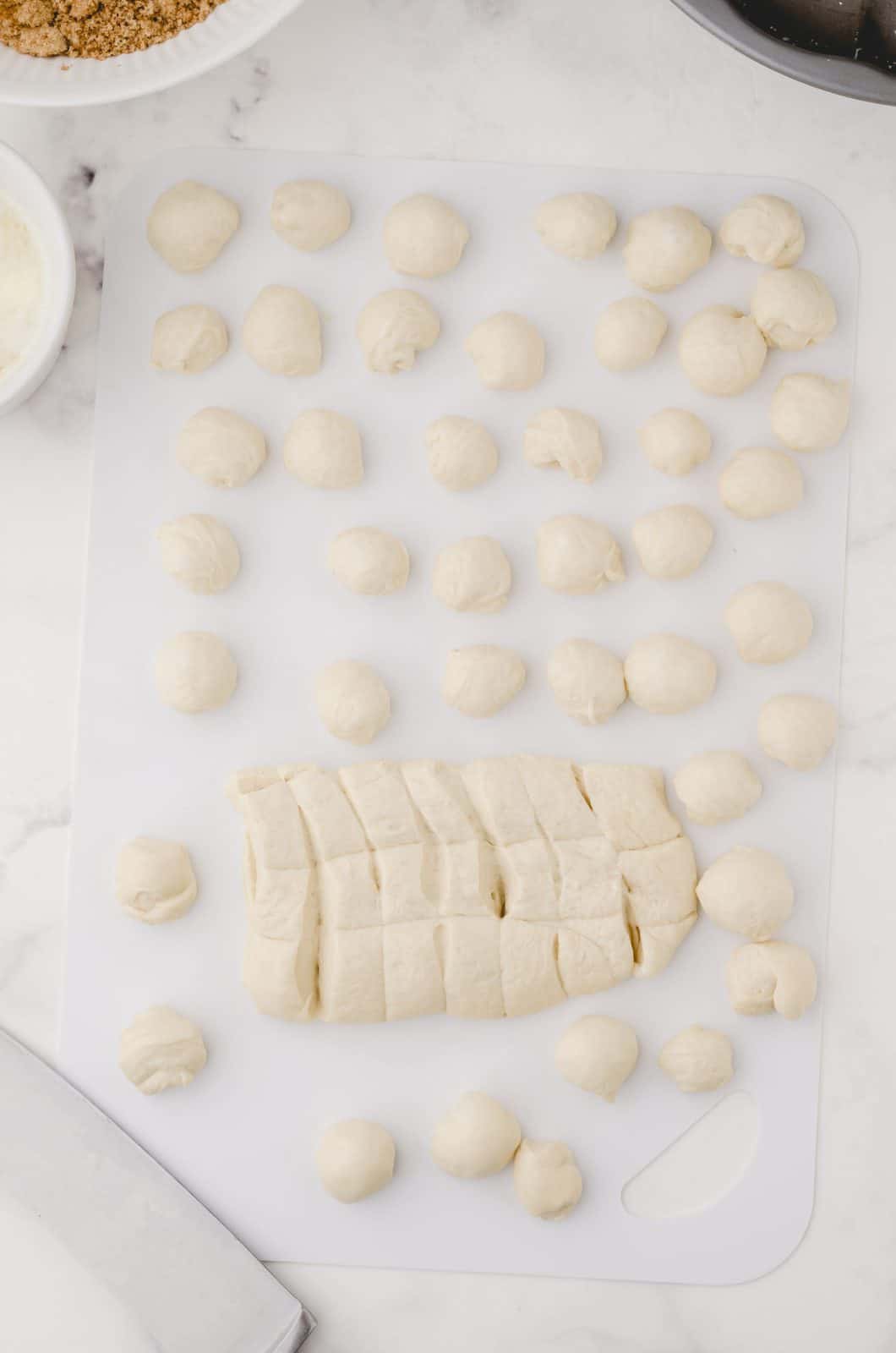 Bread dough being cut and rolled into balls.