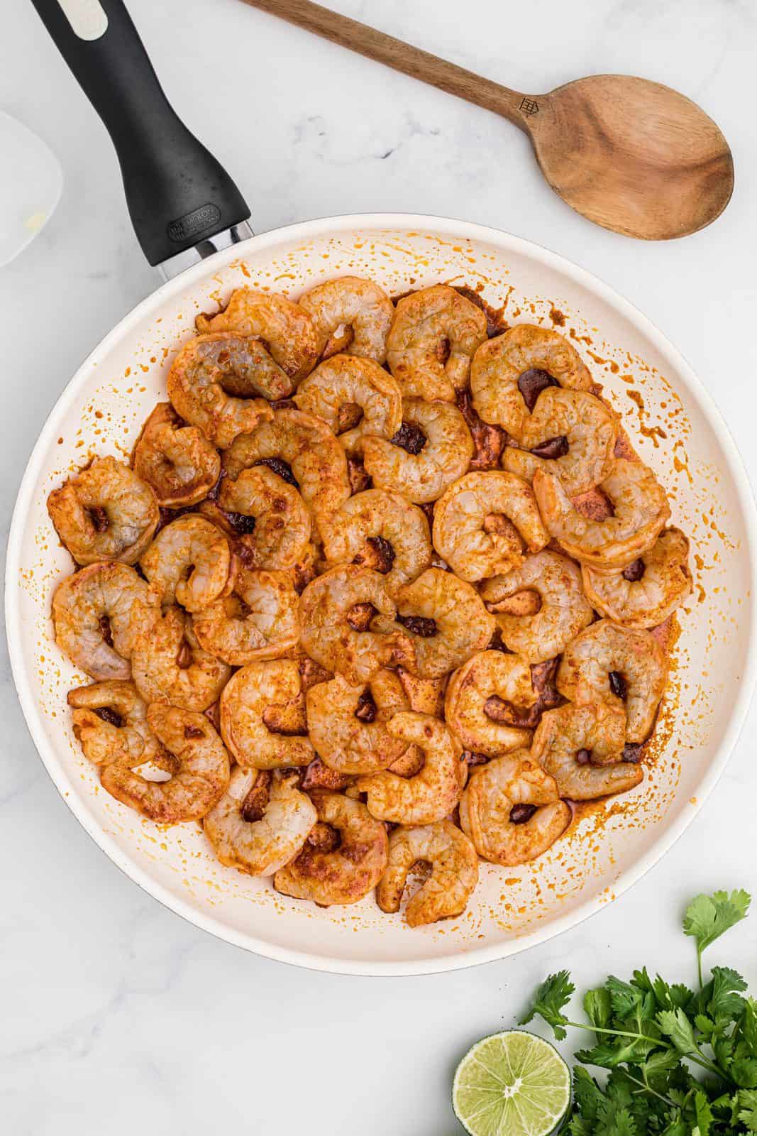 Coated shrimp added to pan.