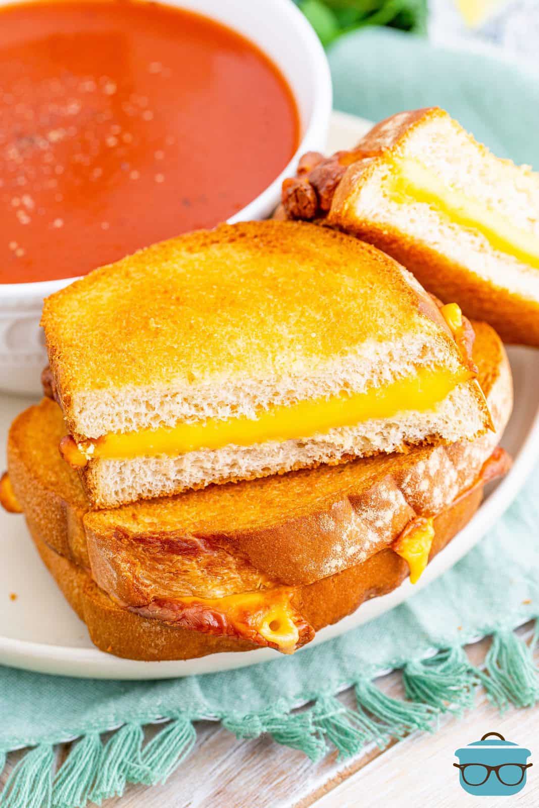 Stacked Air Fryer Grilled Cheese on plate with side of tomato soup.
