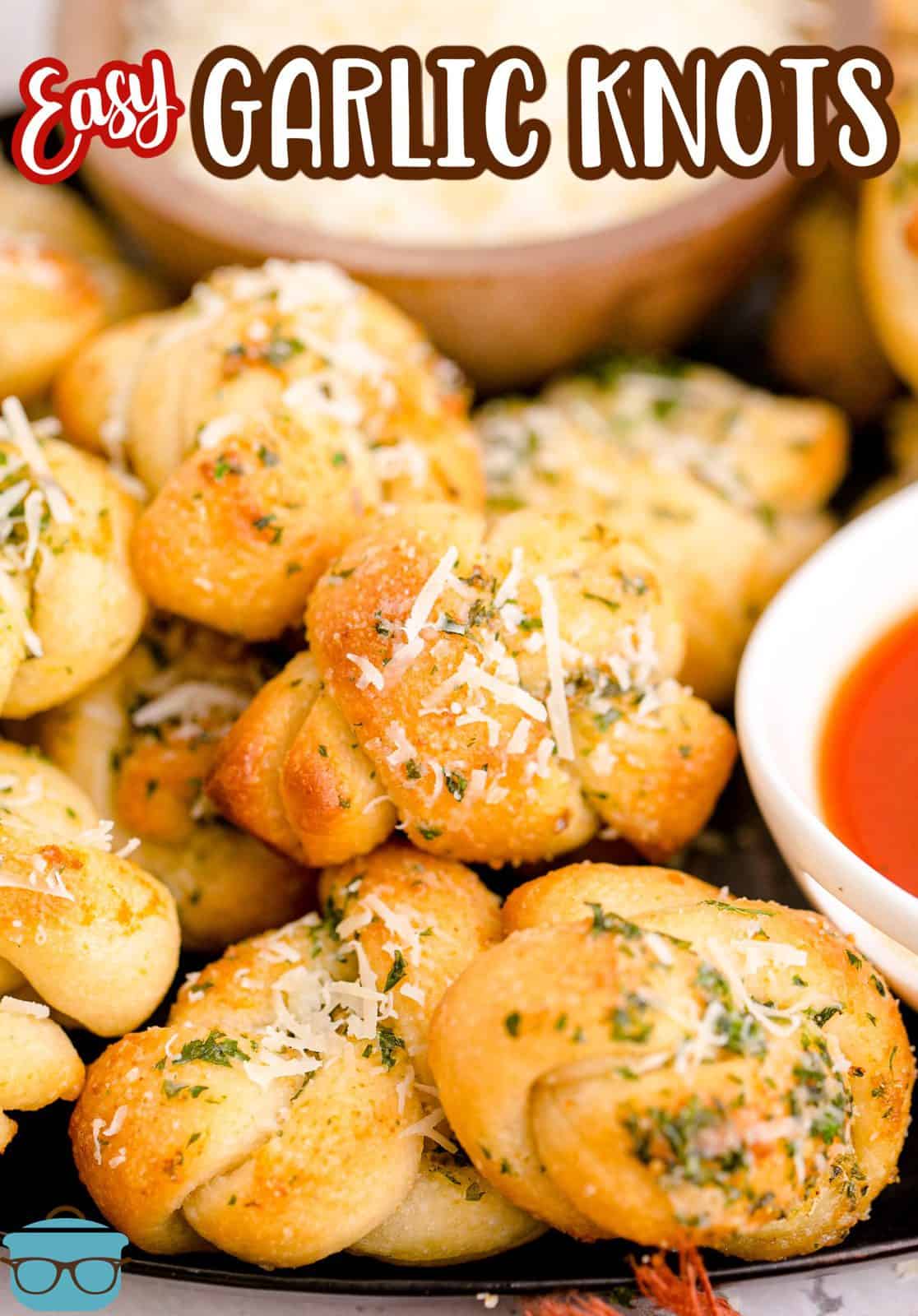 Close up of stacked Easy Garlic Knots on plate with dipping sauce Pinterest image.
