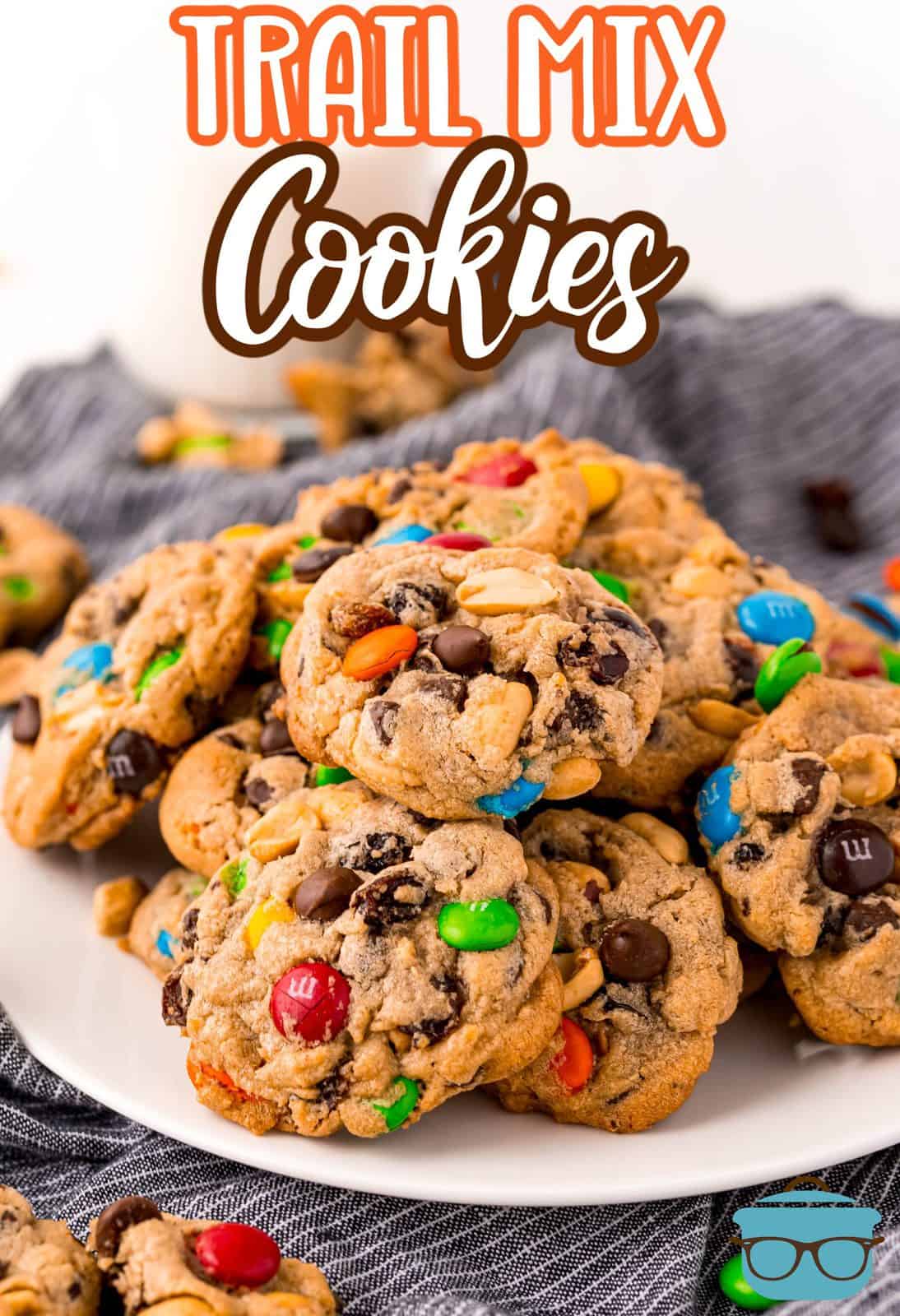 Trail mix cookies on white plate showing ingredients Pinterest image.