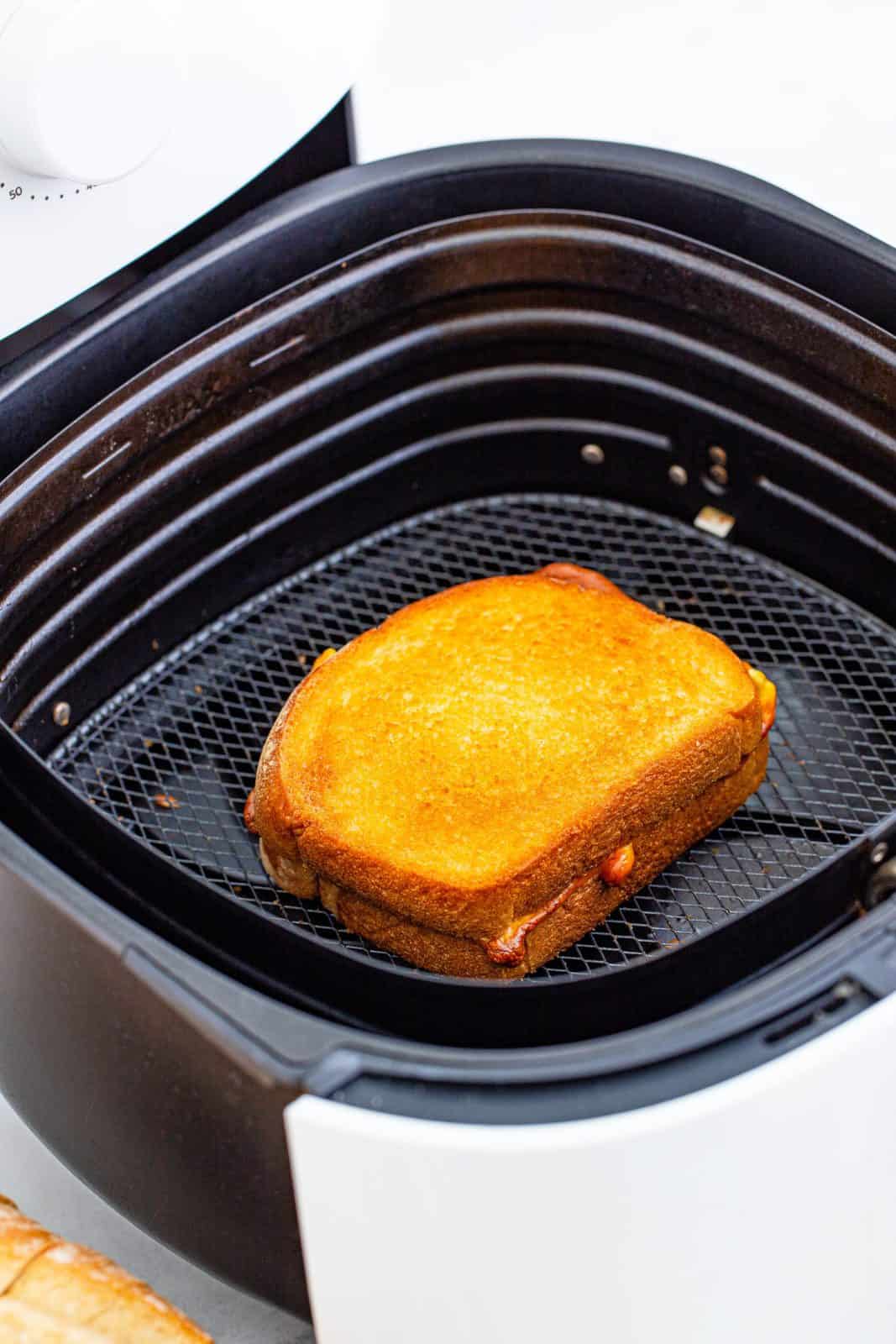 Finished Grilled Cheese in air fryer basket.