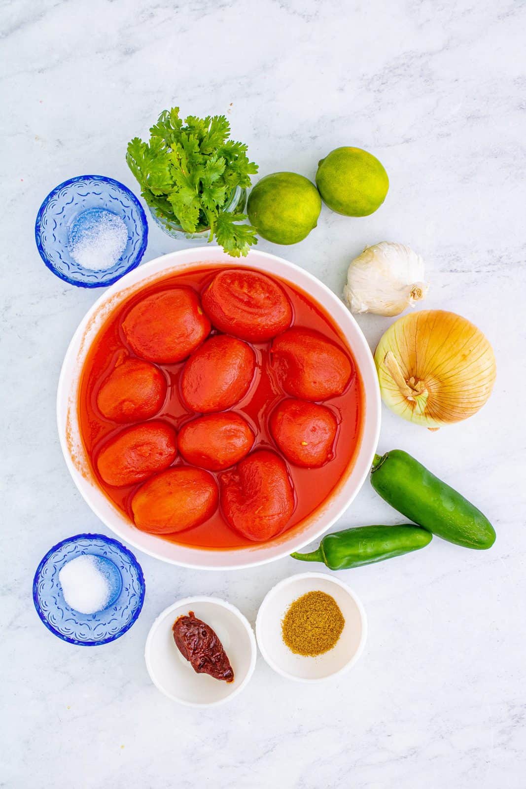 Ingredients needed: peeled tomatoes, with their juice, cilantro, sweet onion, jalapeño, garlic, chipotle in adobo, lime juice, ground cumin, granulated sugar and kosher salt.