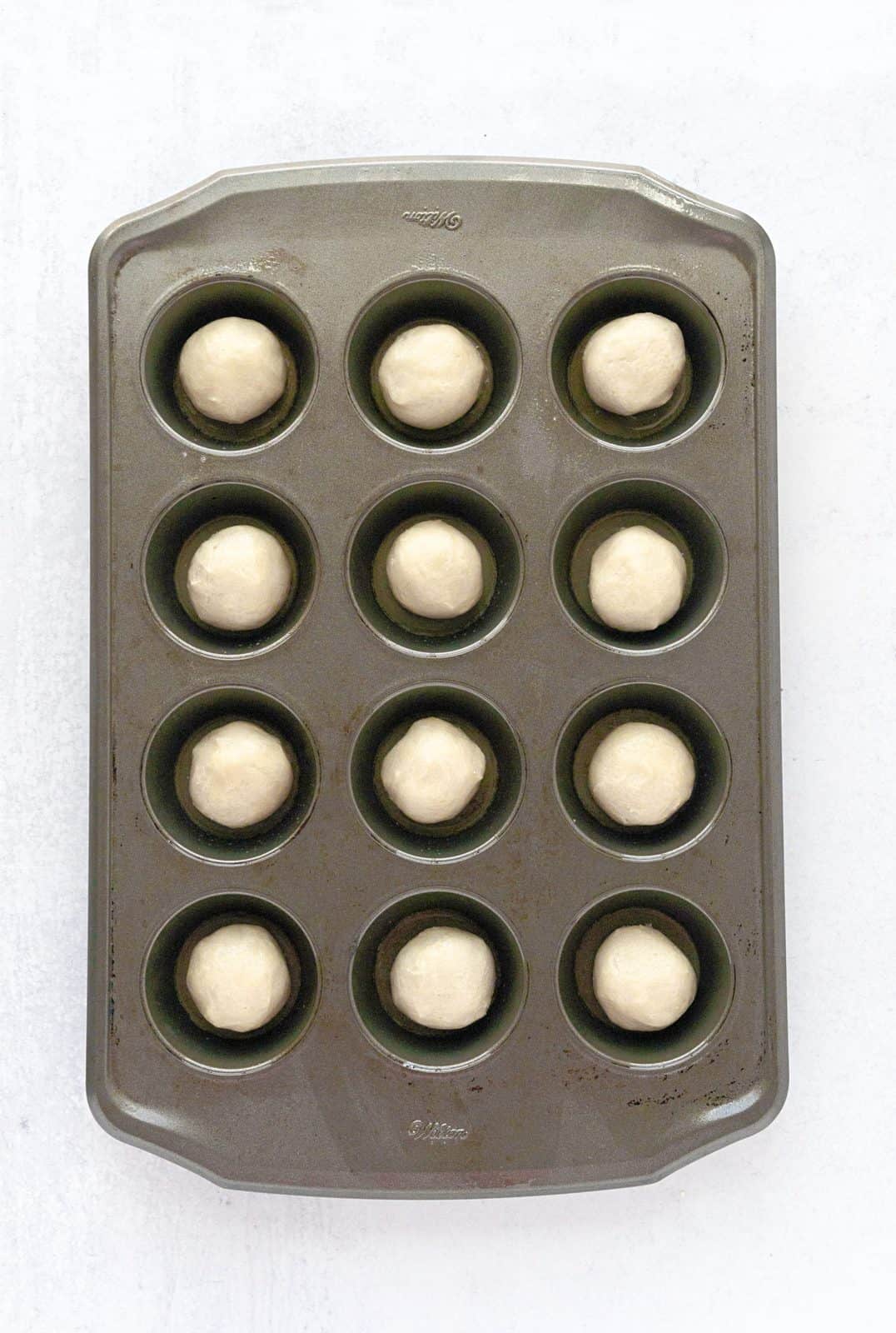 Cookie dough placed into muffin tin.