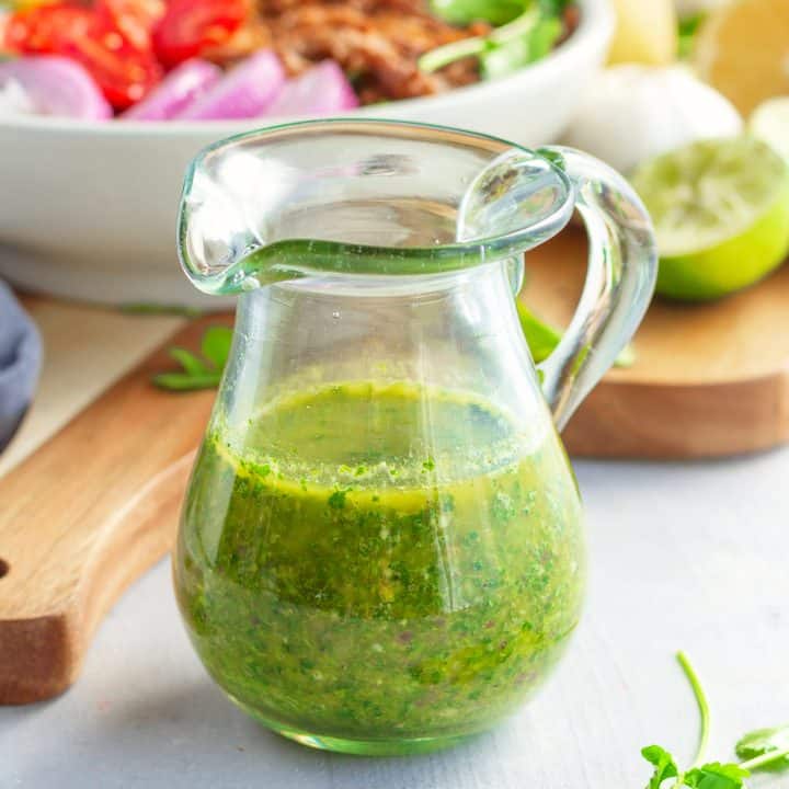 Square image of glass pourable container with Chimichurri Sauce.