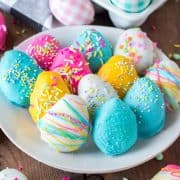 Square image of various colored Easter Egg Oreo Truffles on white plate.