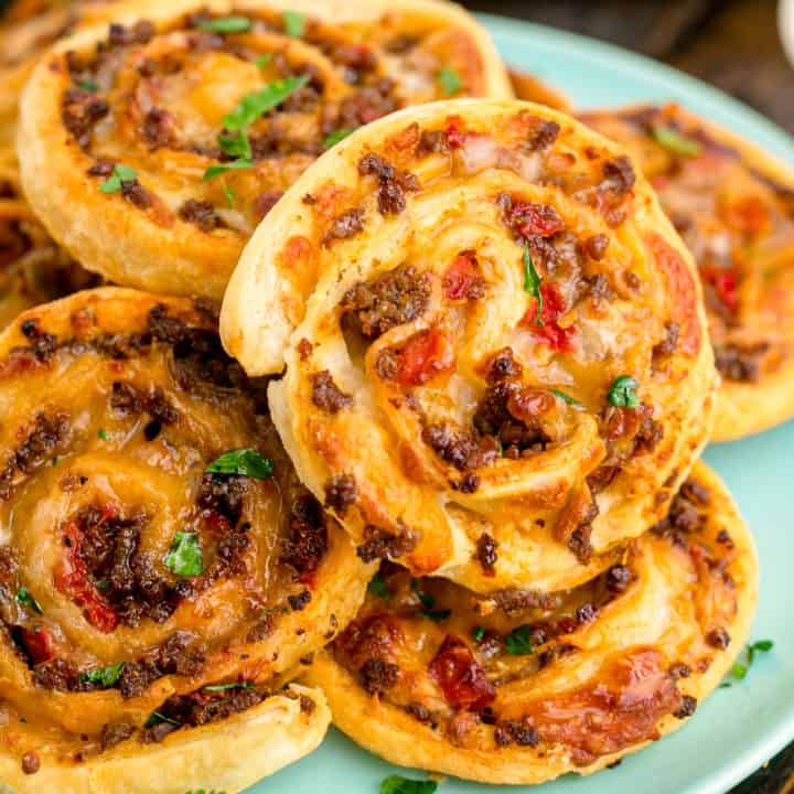 Square image of stacked Taco Pinwheels on blue plate.