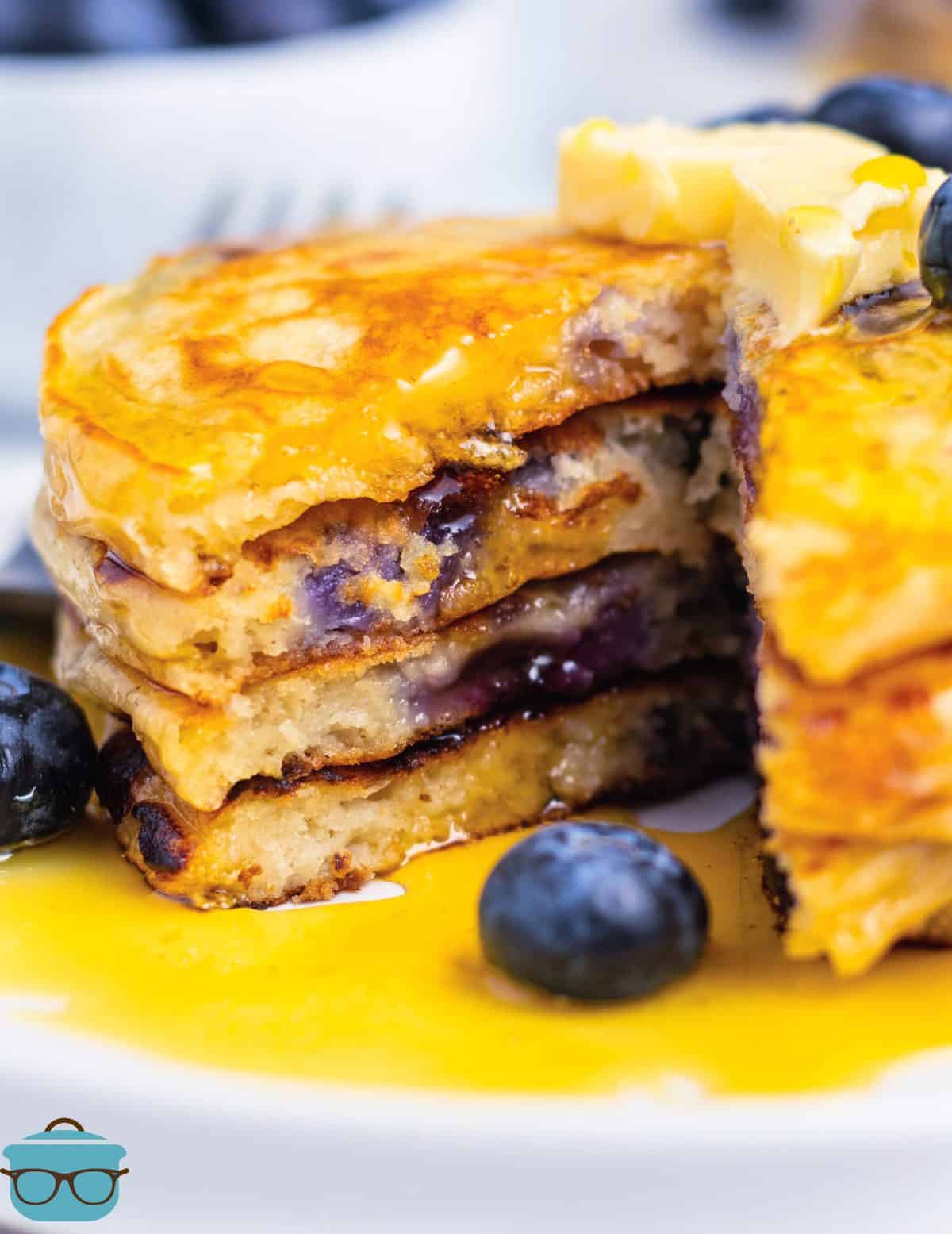 Stack of Blueberry Pancakes with some of the pancake cut out.