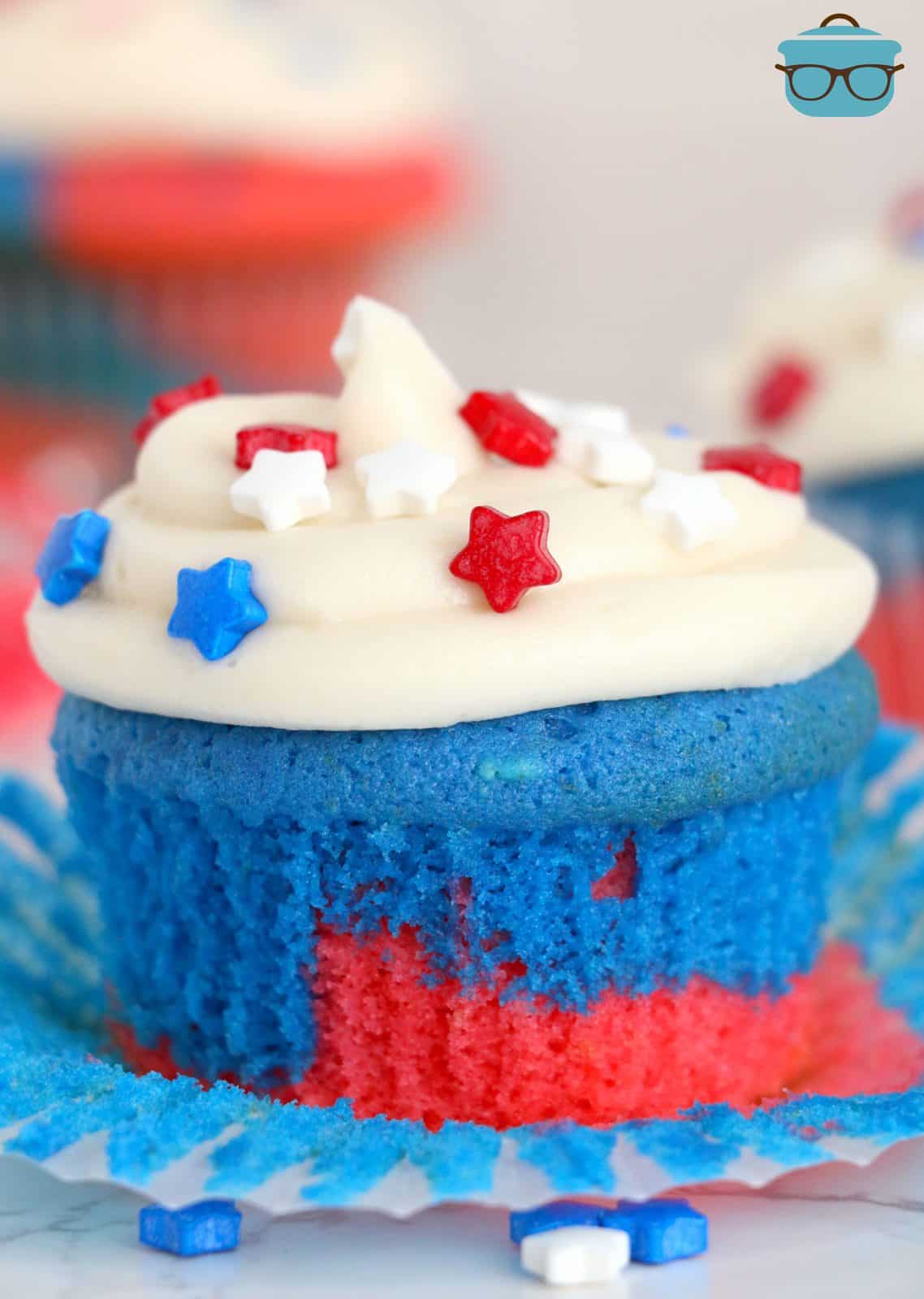 Red, White and Blue Cupcakes with paper liner pulled down and frosted with star sprinkles.