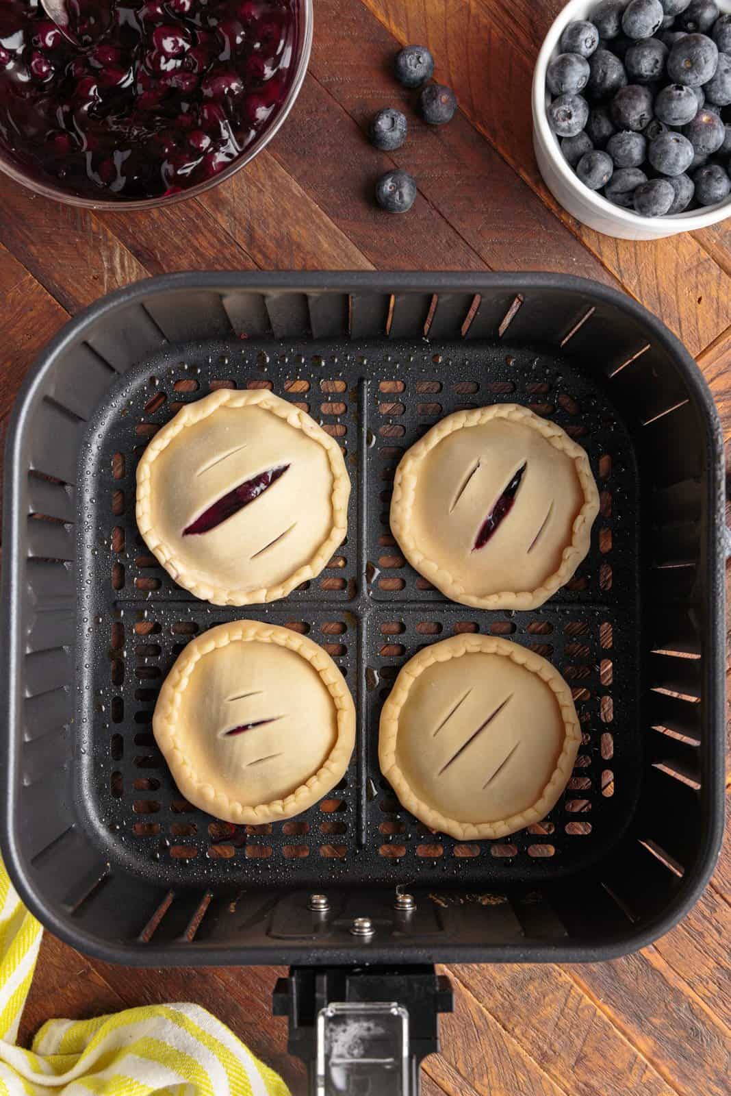 Hand pies placed into basket of air fryer.