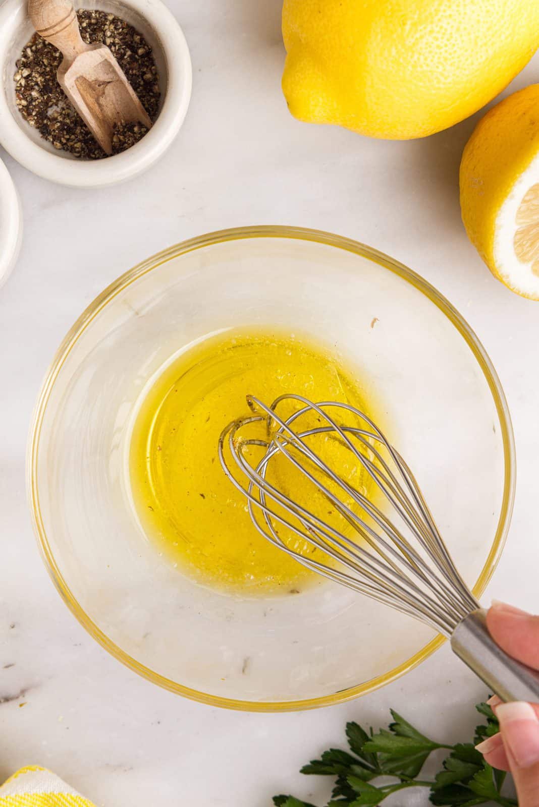 Oil and lemon juice whisked together in bowl.