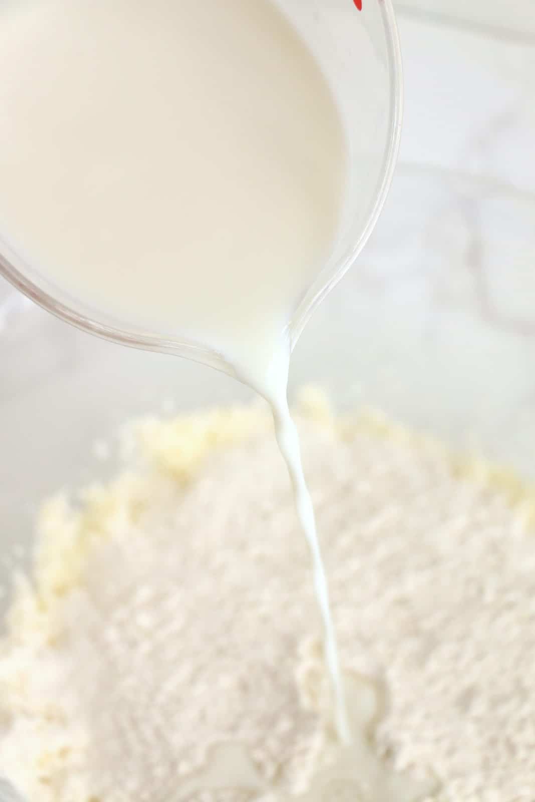 La farina e il latte vengono alternati nella miscela di pastella nella ciotola.