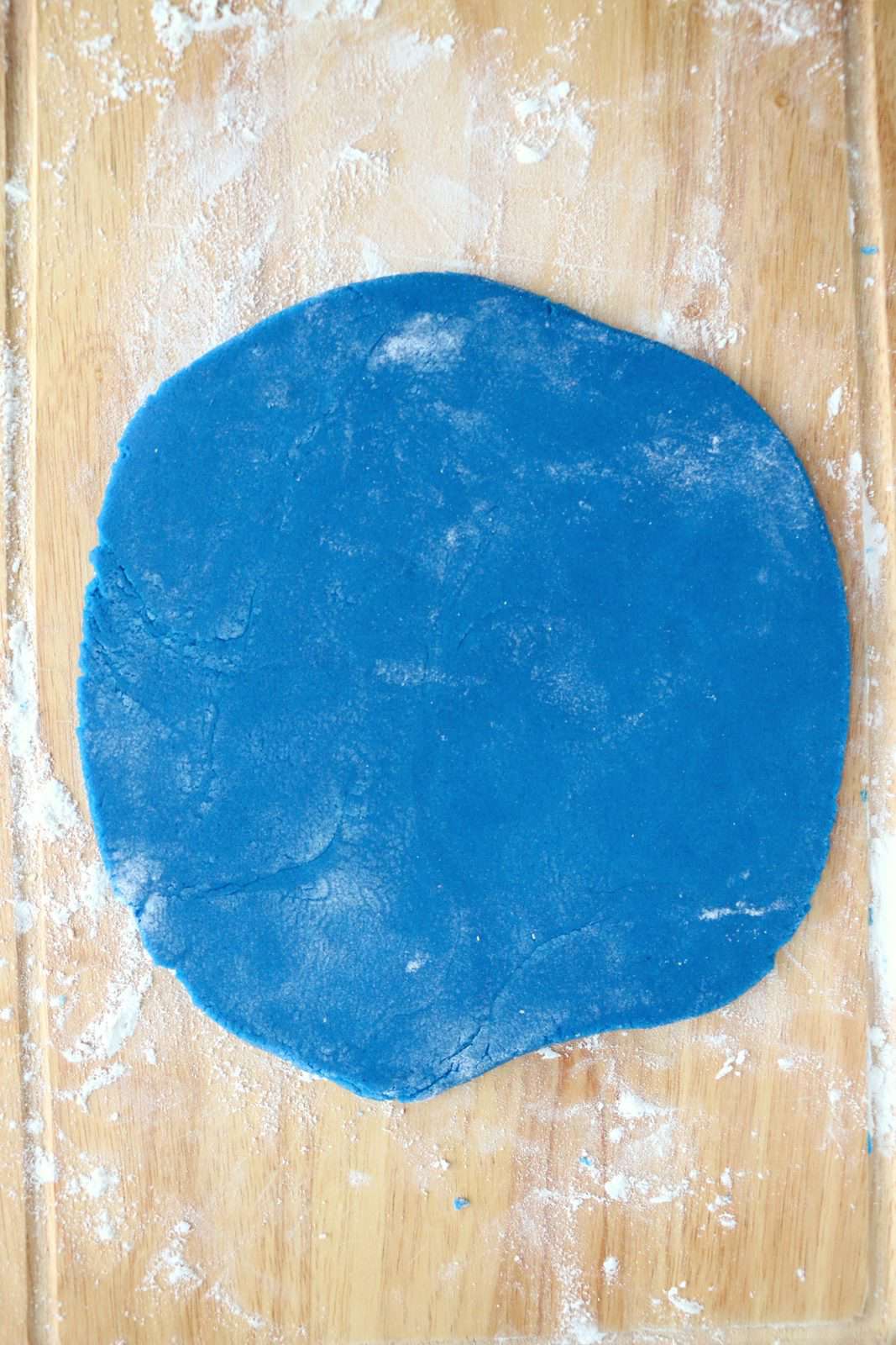 Blue dough rolled out into a square.