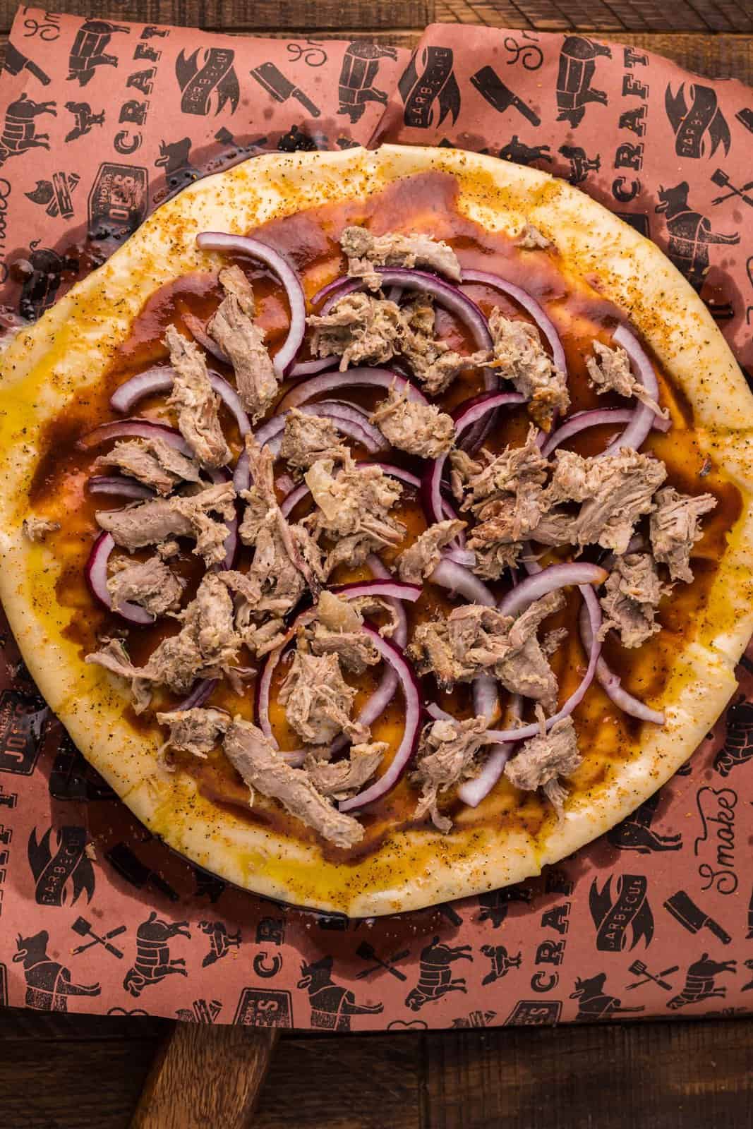 Pulled pork and red onions added to pizza dough.