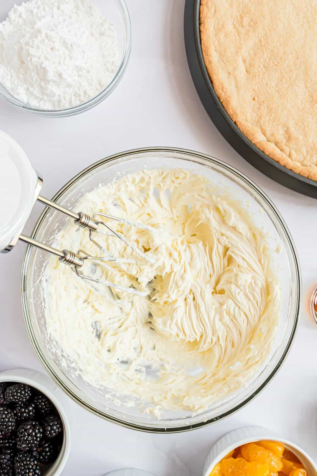 Burro e crema di formaggio sbattuti insieme in una ciotola.