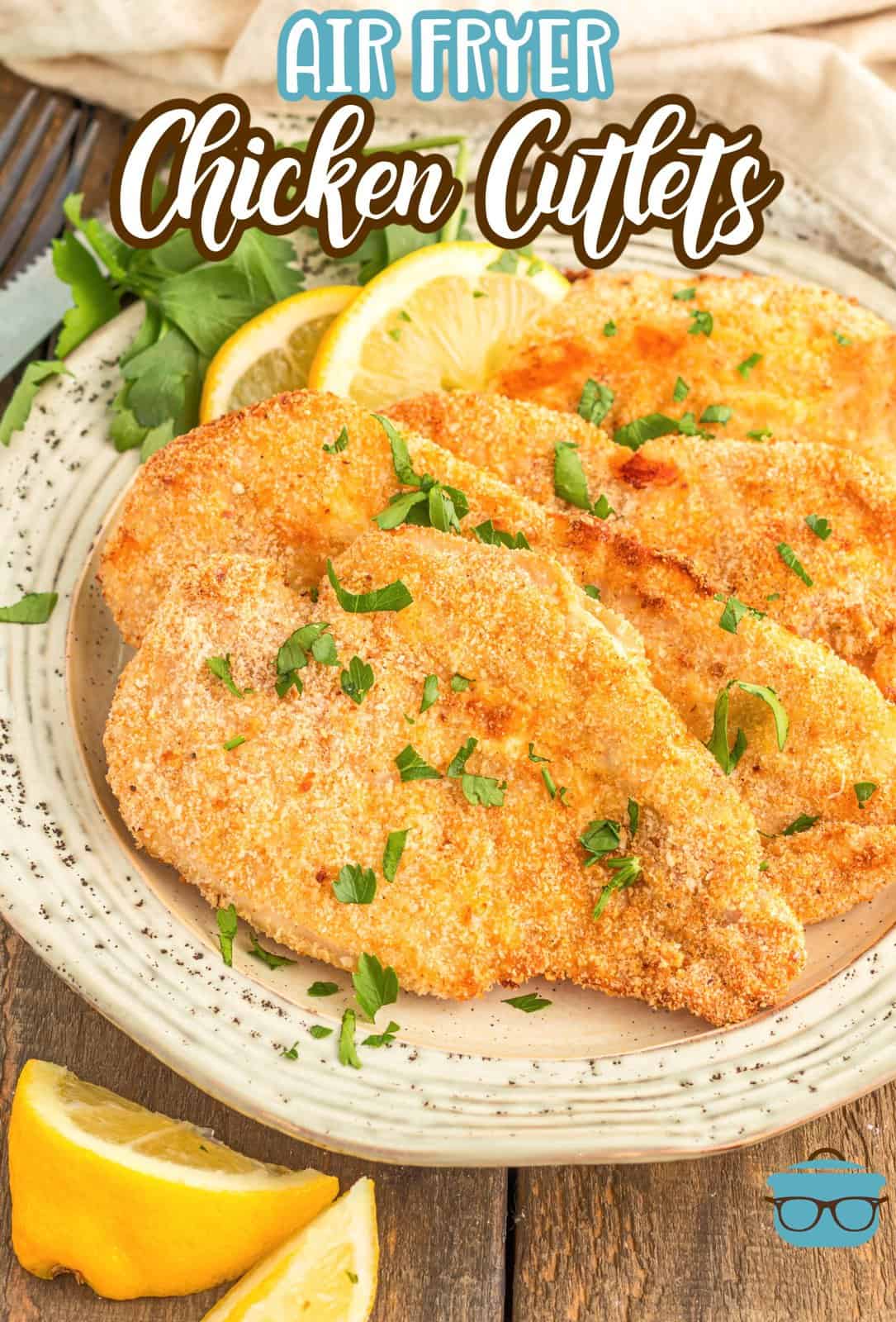 Pinterest image of layered Air Fryer Chicken Cutlets on plate with lemon wedges.