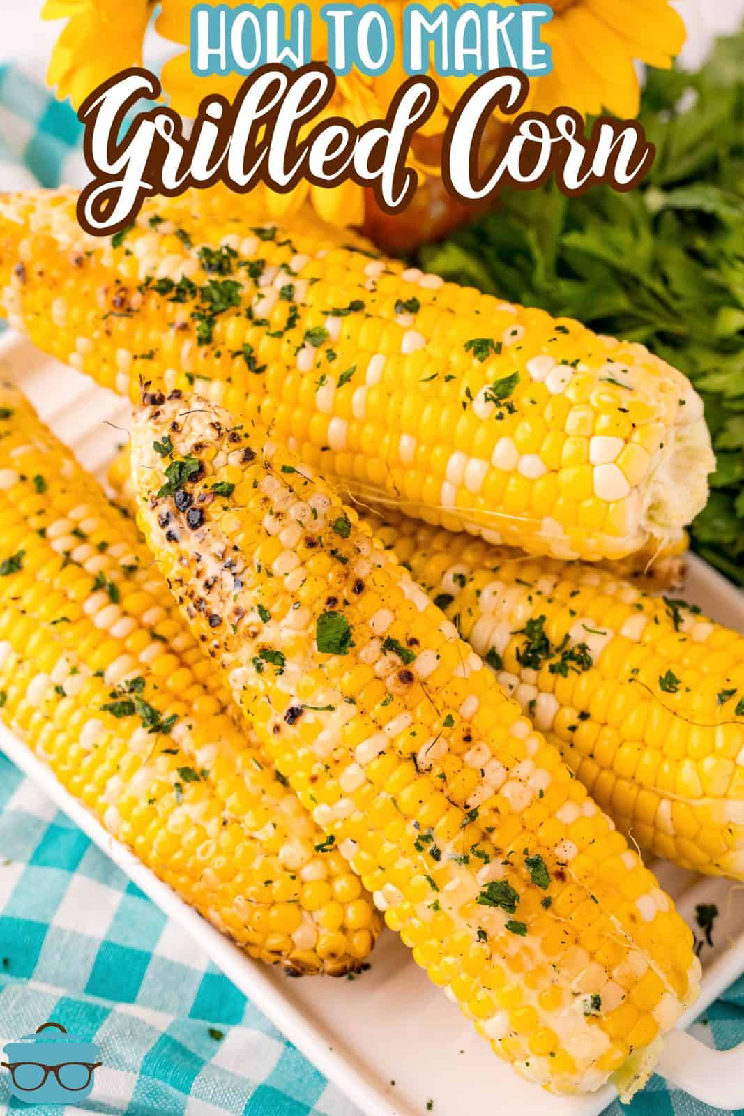 Pinterest image of stacked corn on white platter with butter and herbs.