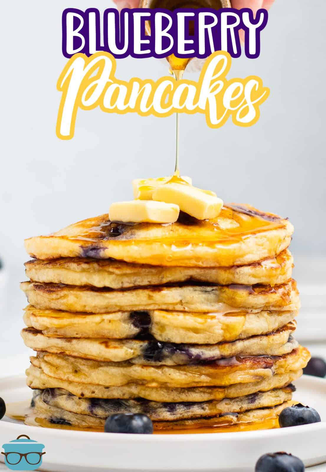 Multiple stacked Blueberry Pancakes on plate topped with butter pinterest image.