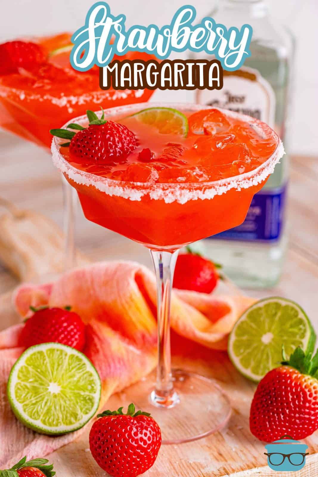 Pinterest image of Strawberry Margaritas in long stemmed glasses with limes and strawberries surrounding them.