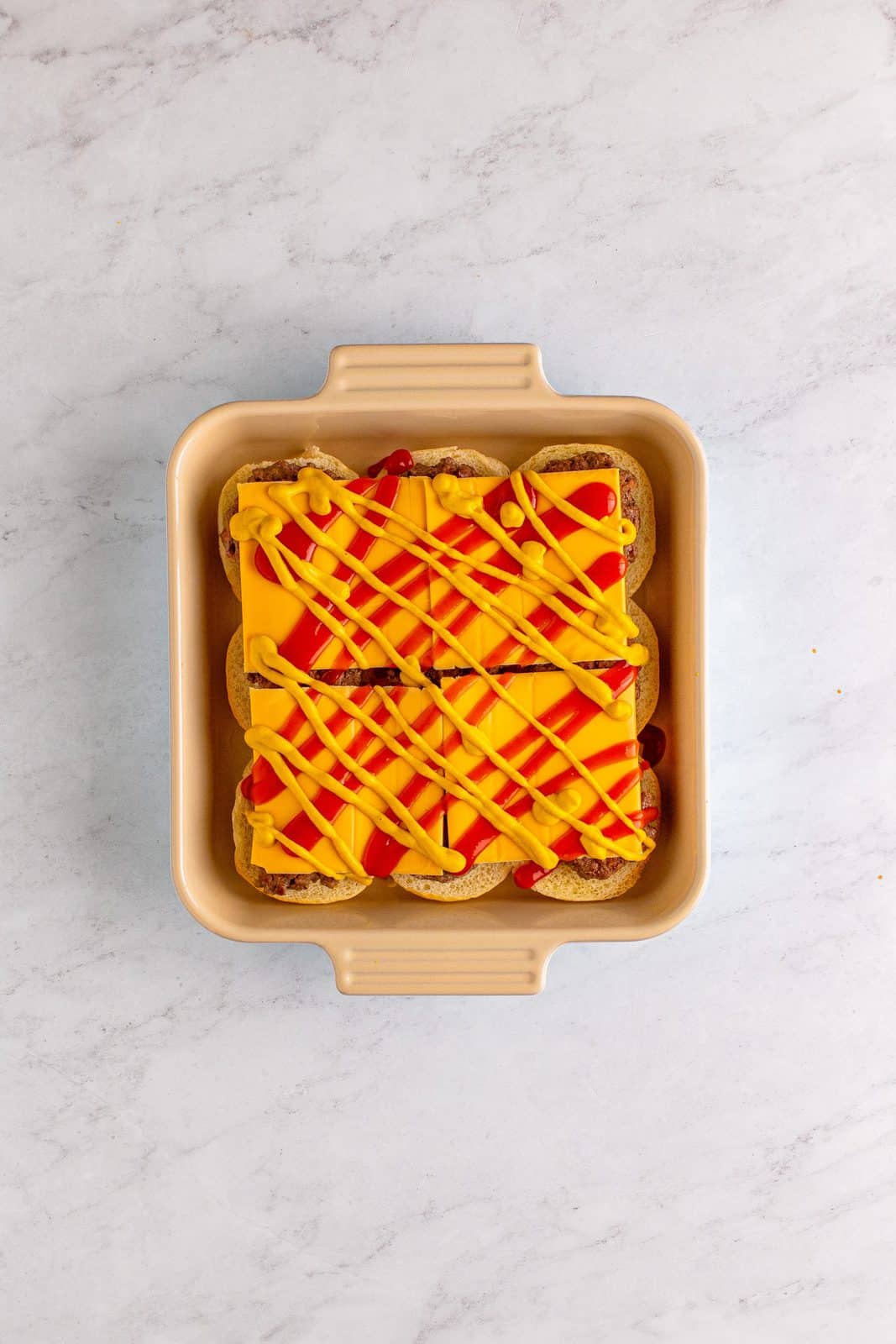 Ketchup and mustard added to the top of the cheese slices.