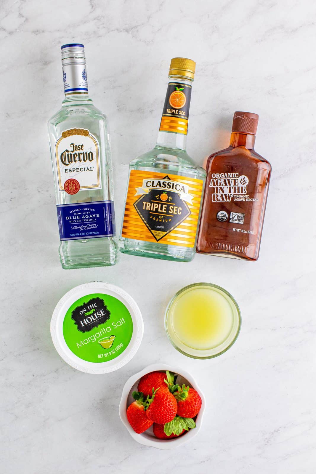 Ingredients needed: strawberries, tequila, triple sec, lime juice, agave syrup, Margarita salt, ice and limes.