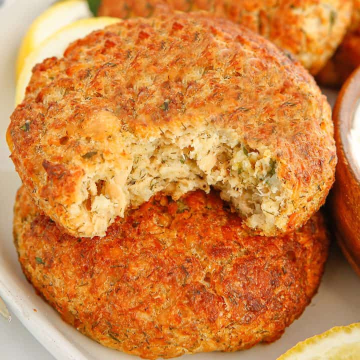 Square image of Air Fryer Salmon Patties stacked with bite taken out of one.