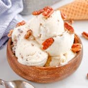 Square image close up of No-Churn Butter Pecan Ice Cream in wooden bowl topped with more pecans.