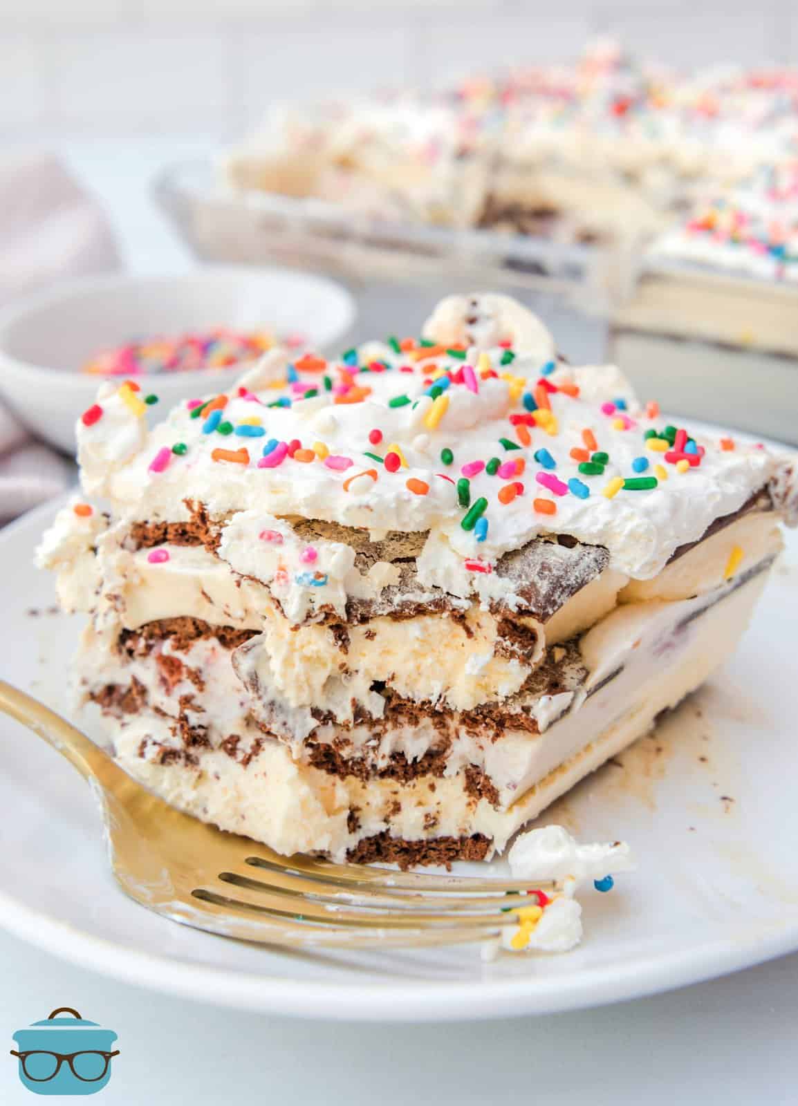 Slice of Ice Cream Sandwich Cake on white plate with bite taken out of it.