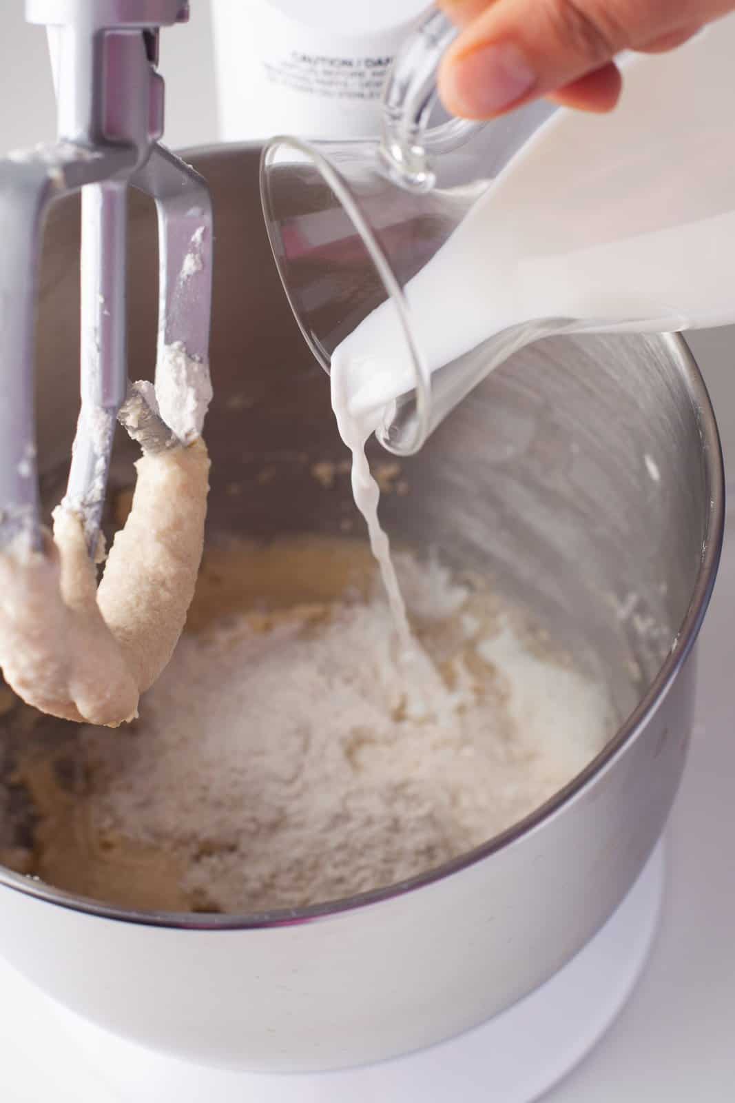 Milk and vanilla being alternated with dry ingredients in stand mixer.