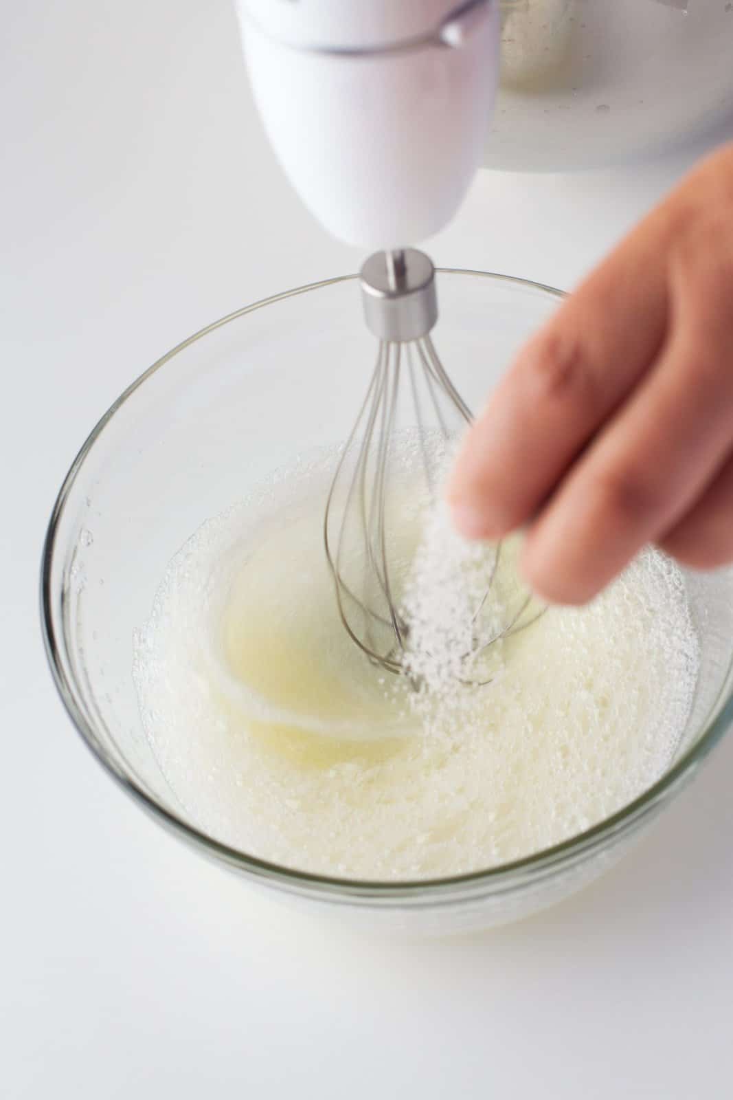 Egg whites being whisked with remaining sugar.