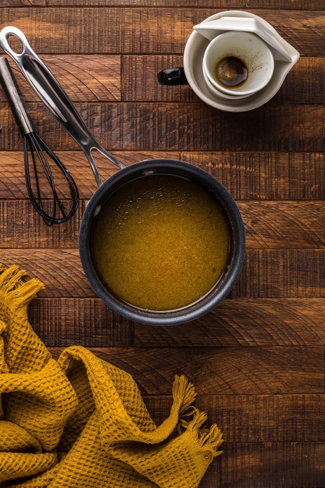 Apple cider vinegar, worcheshire sauce, olive oil, and garlic paste whisked together in saucepan.