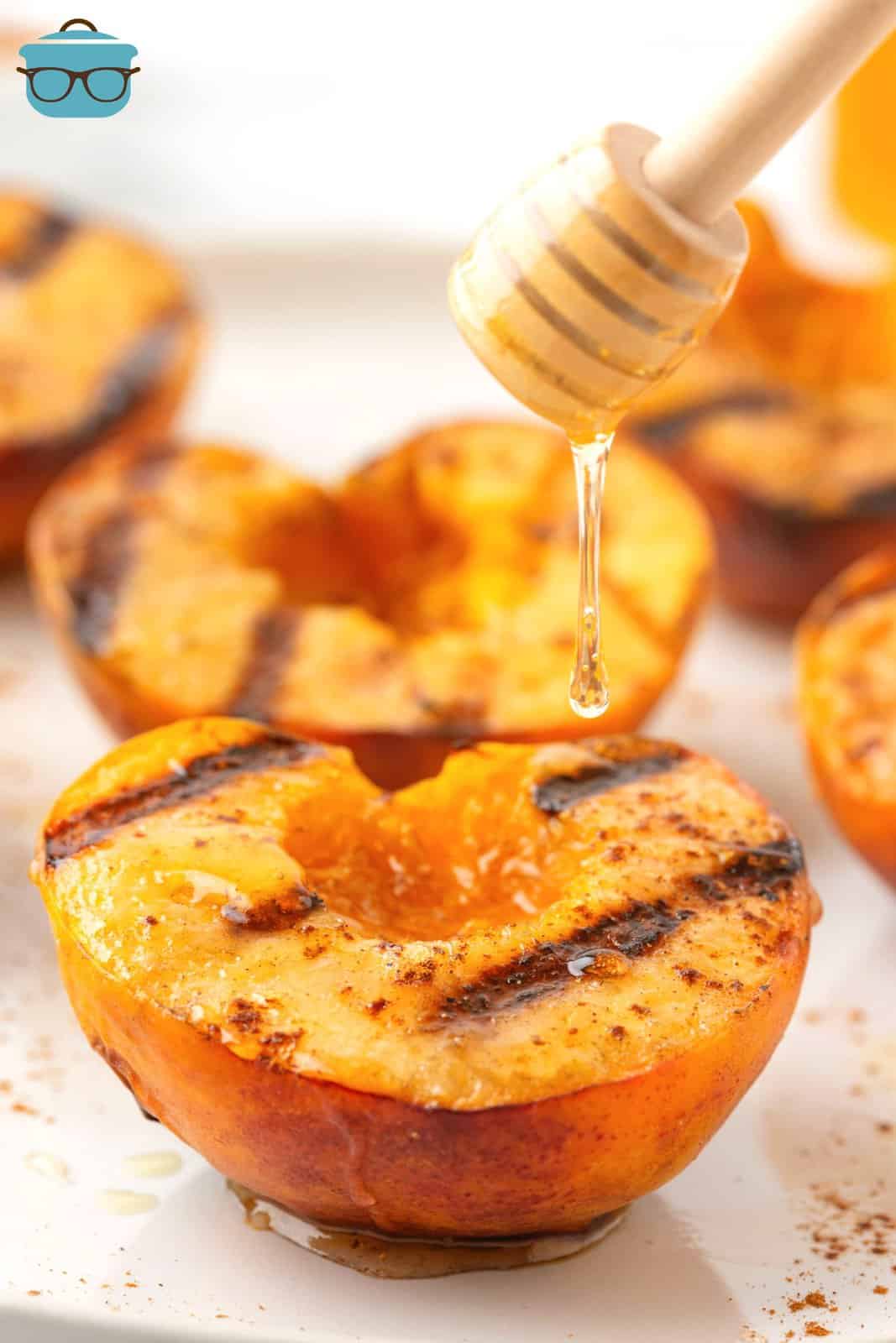 Honey being drizzled over Grilled Peaches.