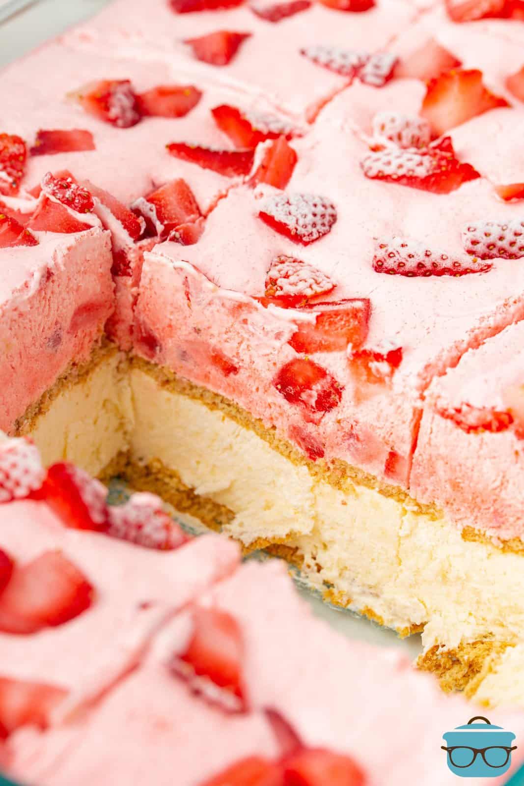 Tagliare le fette di Strawberry Ice Box Cake rimosse dalla teglia mostrando gli strati.
