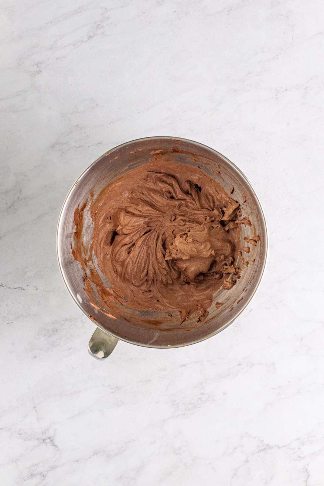 Finished chocolate whipped cream mixture beaten to stiff peaks in stand mixer bowl.