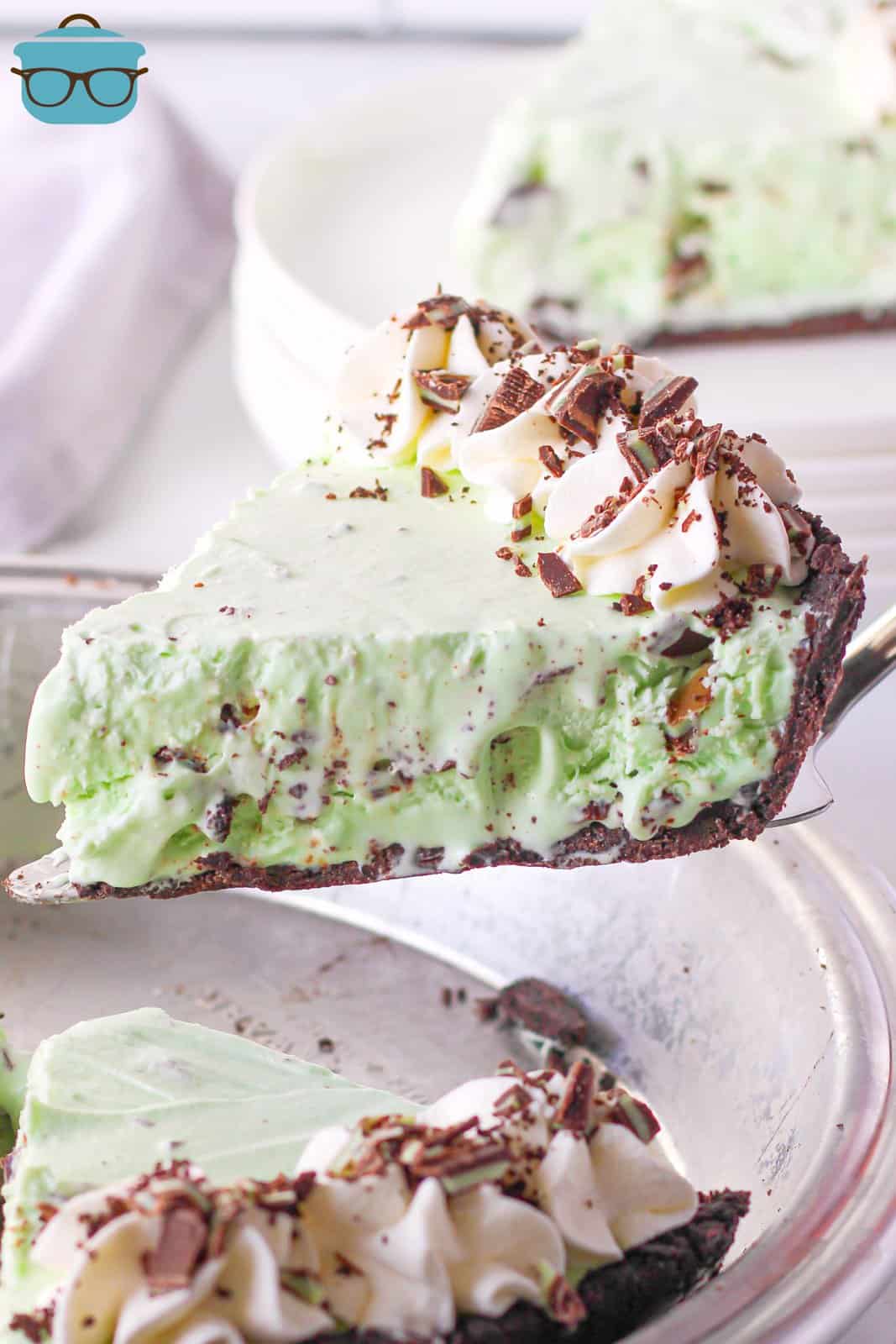 Pie server holding up slice of Mint Chip Ice Cream Pie out of pan.