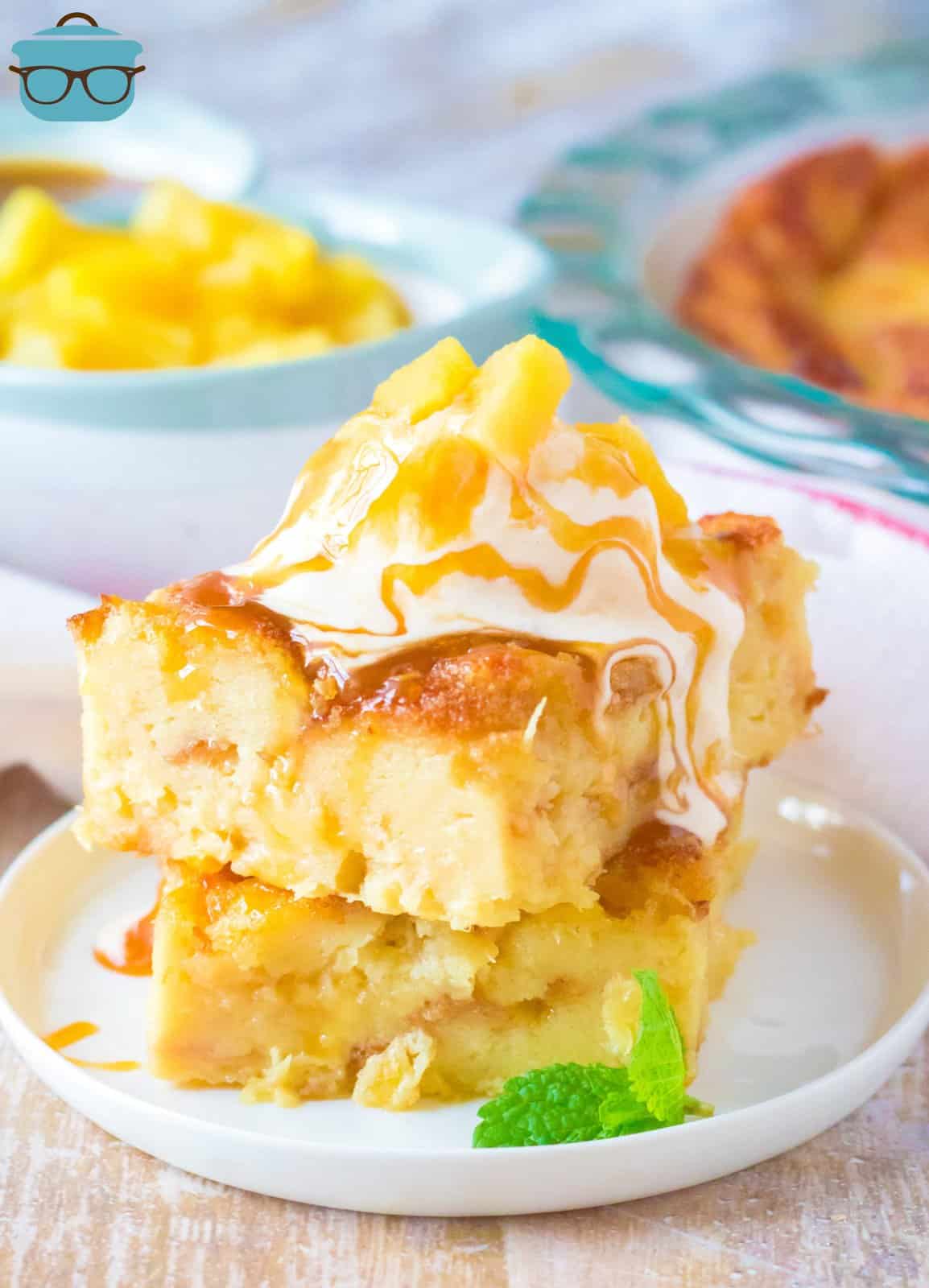 Two stacked slices of Pineapple Bread Pudding on plate topped with ice cream.