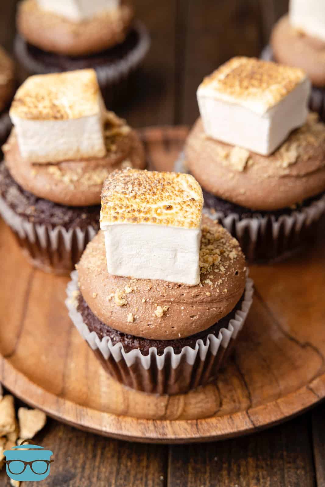 S'mores Cupcakes on wooden board showing off the toasted marshmallow.