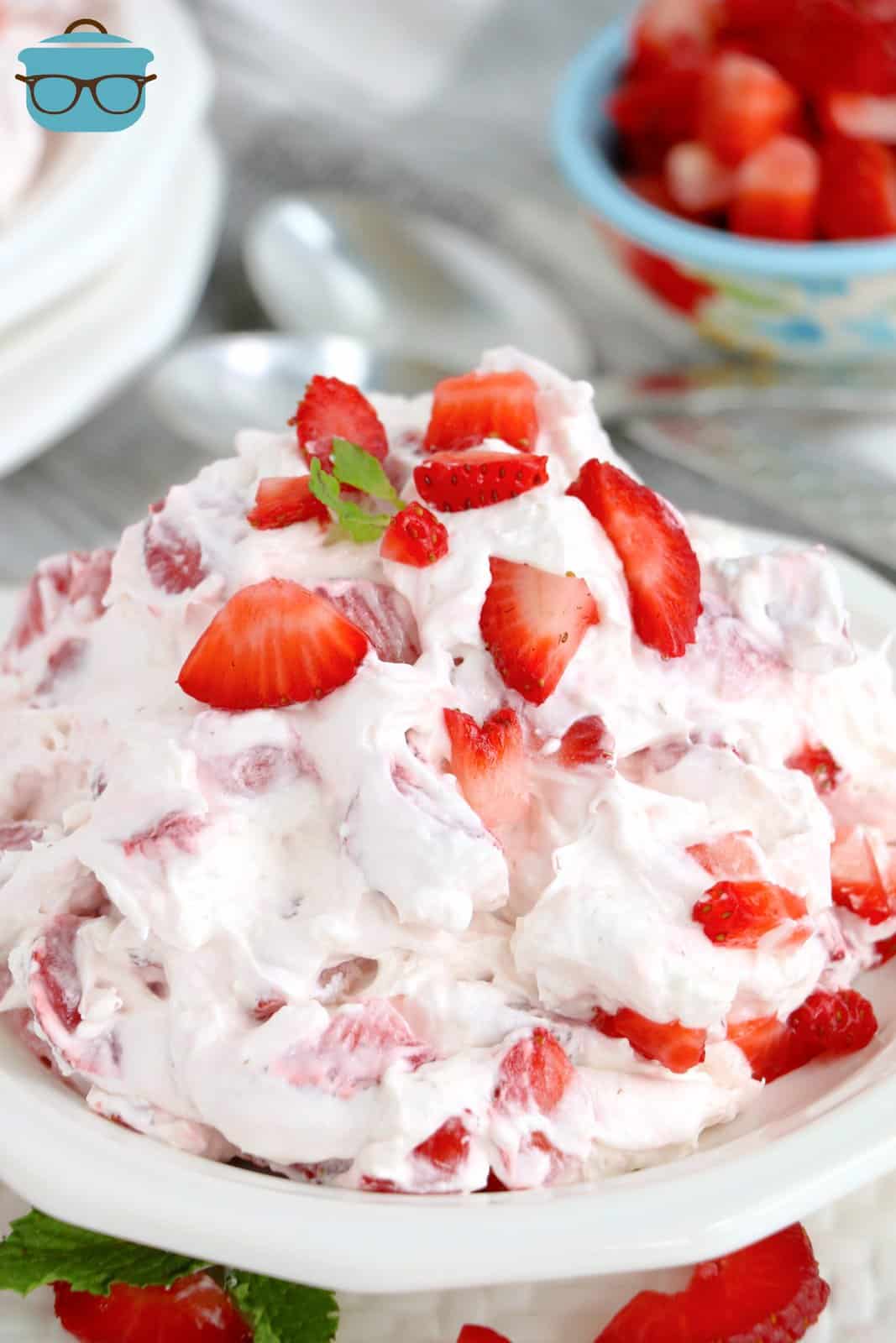 Strawberry Cheesecake Fluff in white bowl topped with strawberries and mint.