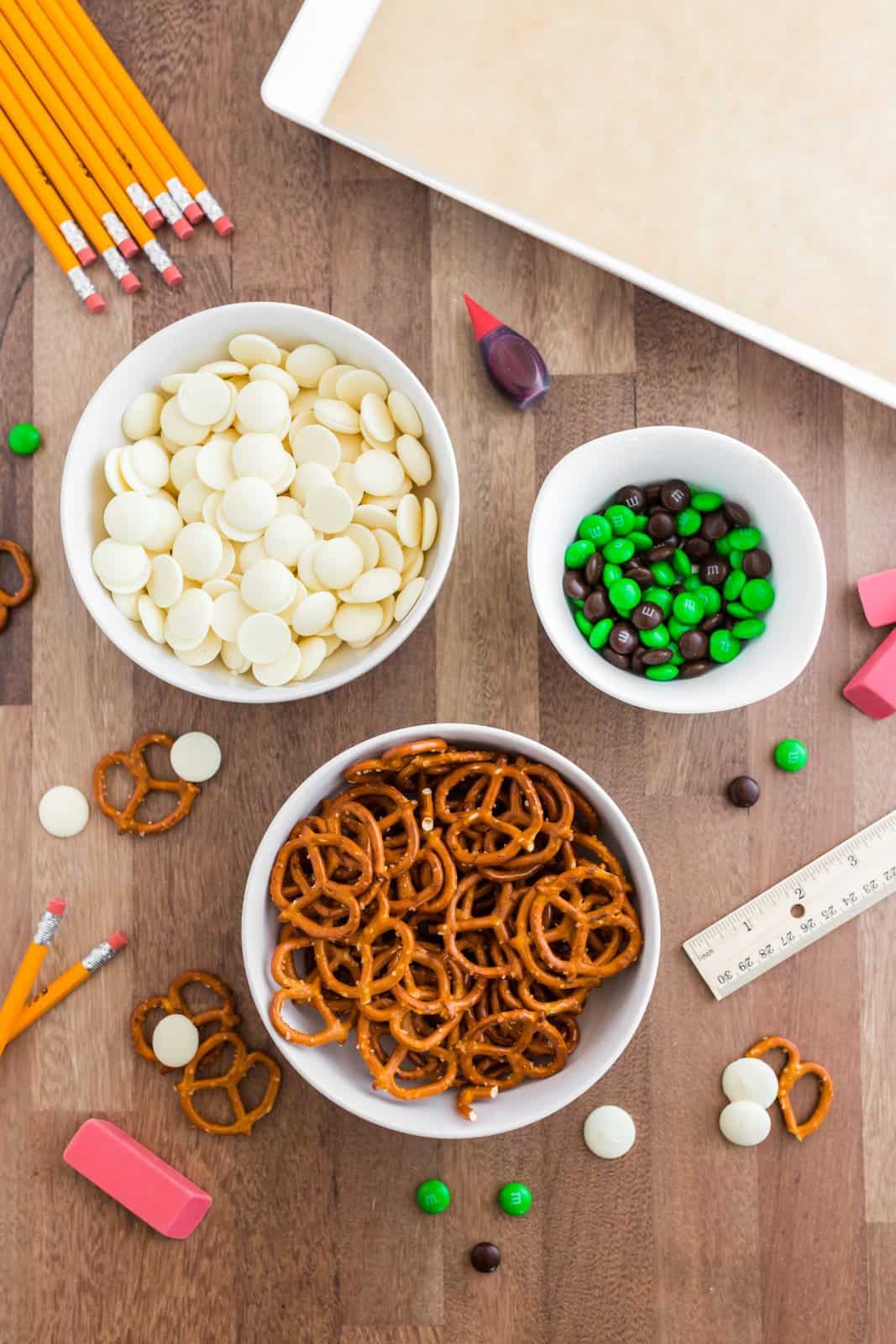 Ingredients needed: white melting chocolate, red food coloring, pretzel twists and green and brown M&Ms.