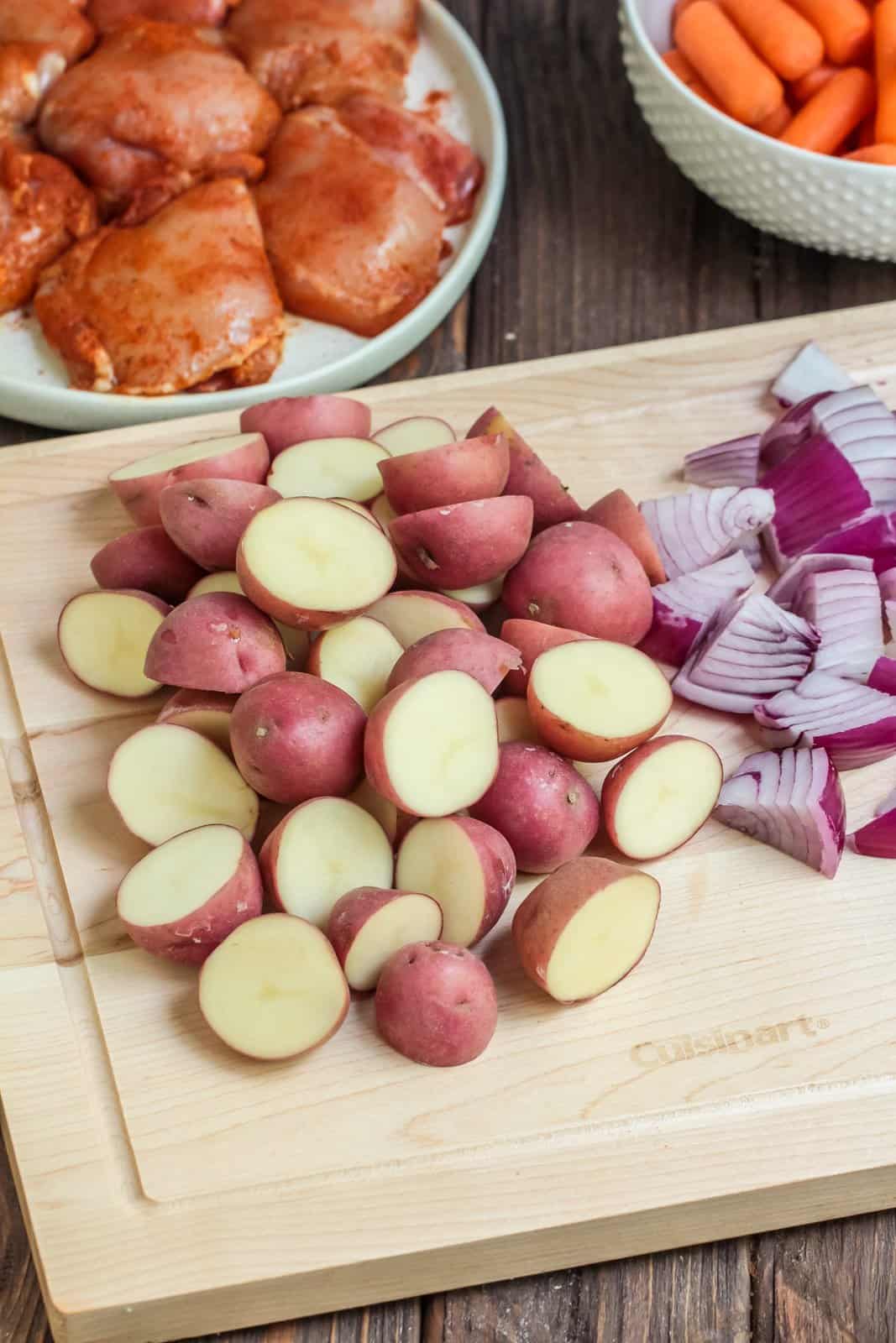 Potatoes and onions cut up on cutting board.