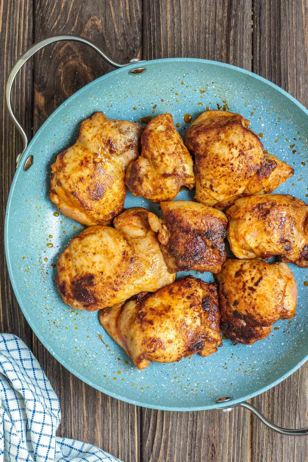 Chicken thighs cooked in pan.
