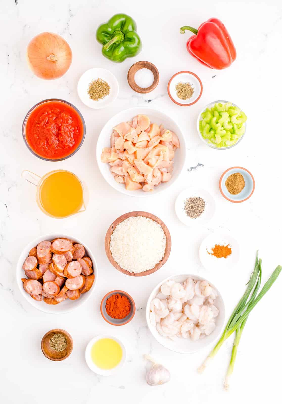 Ingredients needed: cooking oil, andouille sausage, chicken, onion, green bell pepper, red bell pepper, celery, garlic, crushed tomatoes, smoked paprika, salt, cumin, oregano, basil, thyme, pepper, cayenne pepper white rice, chicken broth, shrimp and green onions.