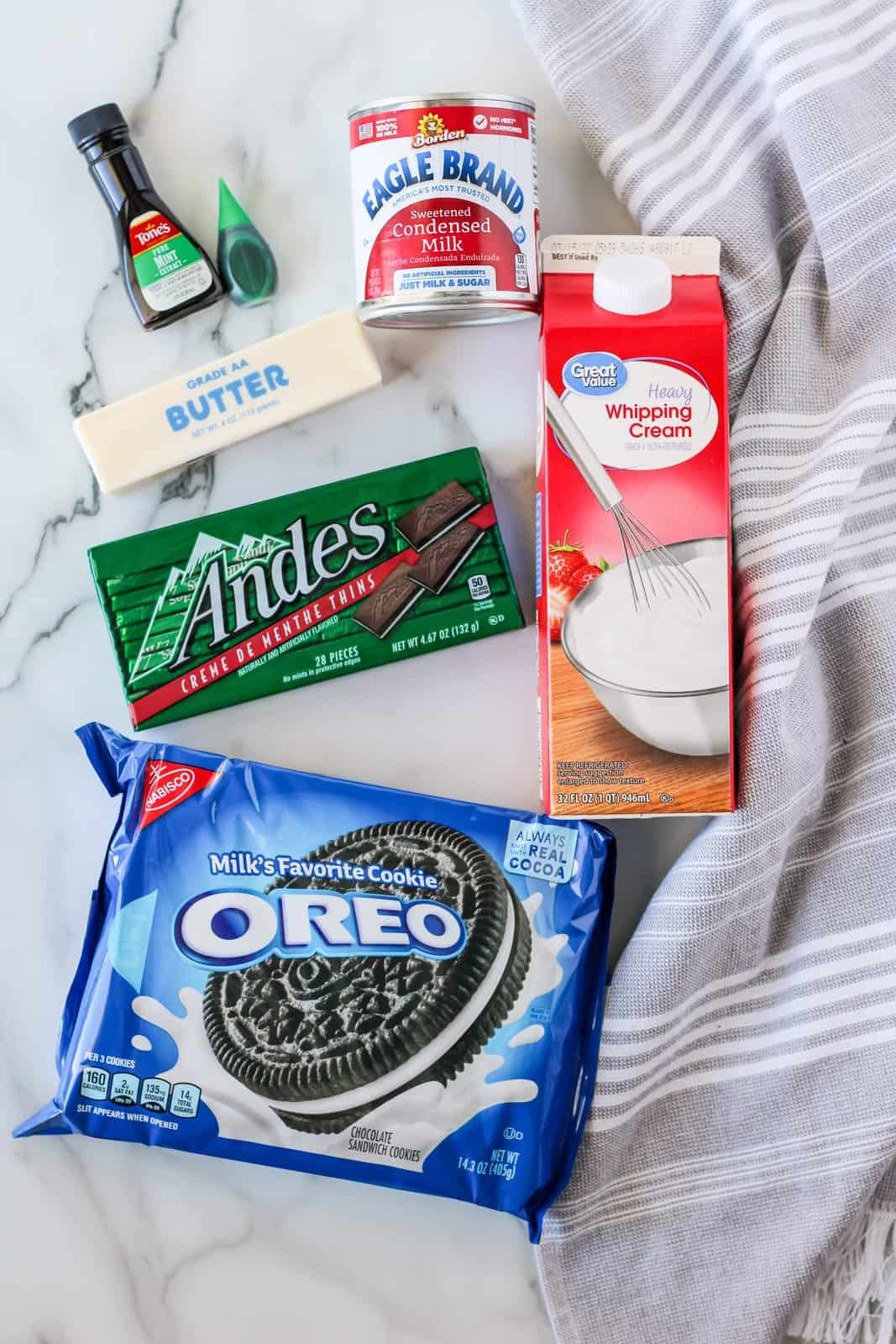 Ingredients needed: unsalted butter, sandwich cookies, heavy whipping cream, sweetened condensed milk, mint extract, green food coloring (optional), chopped mint chocolate.