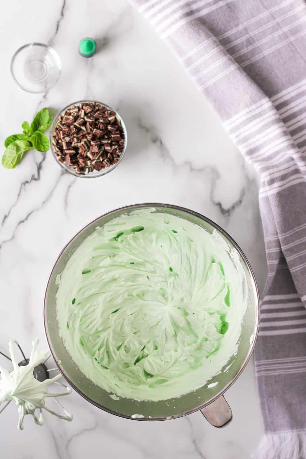 Sweetened condensed milk, food coloring and mint extract added to whipped cream and beaten.