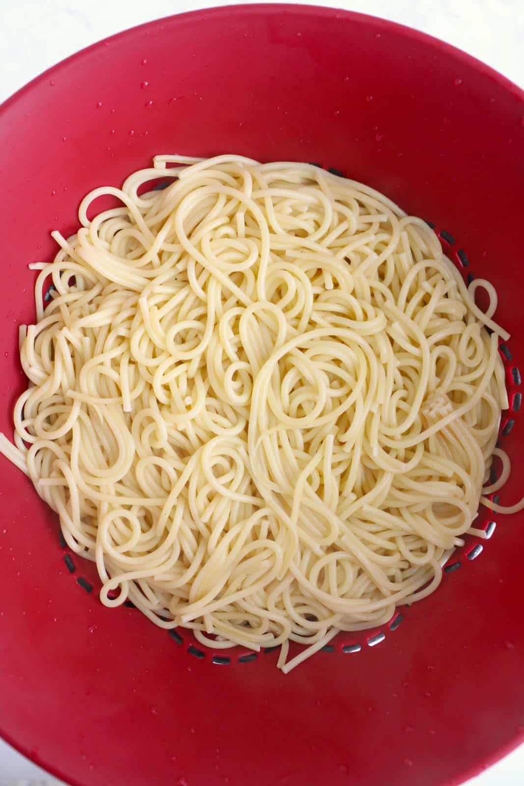 Cooked spaghetti being drained.