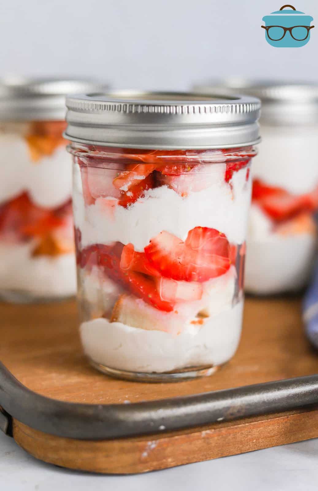 Strawberry Shortcake in a Jar on wooden board with lid on top.