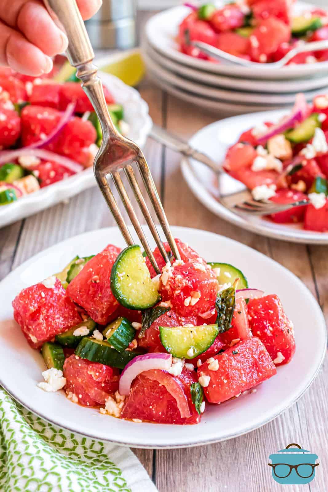 Watermelon Salad on white plate with fork going into one plate of salad.