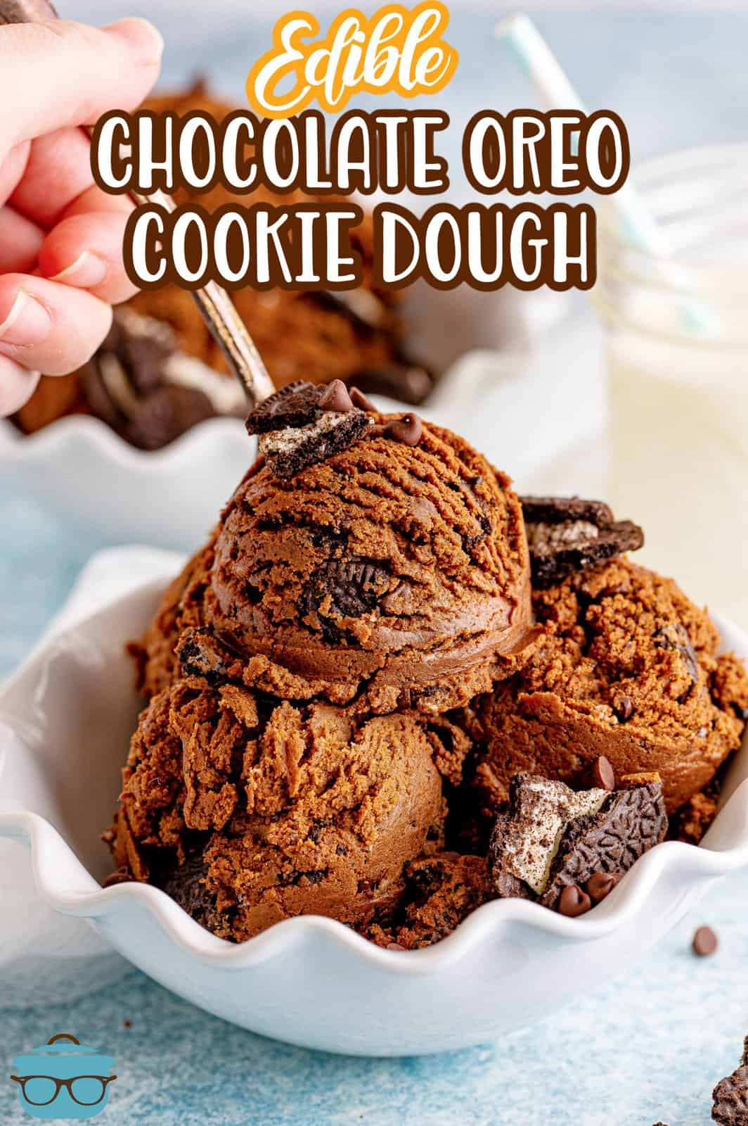 Pinterest image of Edible Chocolate Oreo Cookie Dough in bowl with hand holding spoon in it.