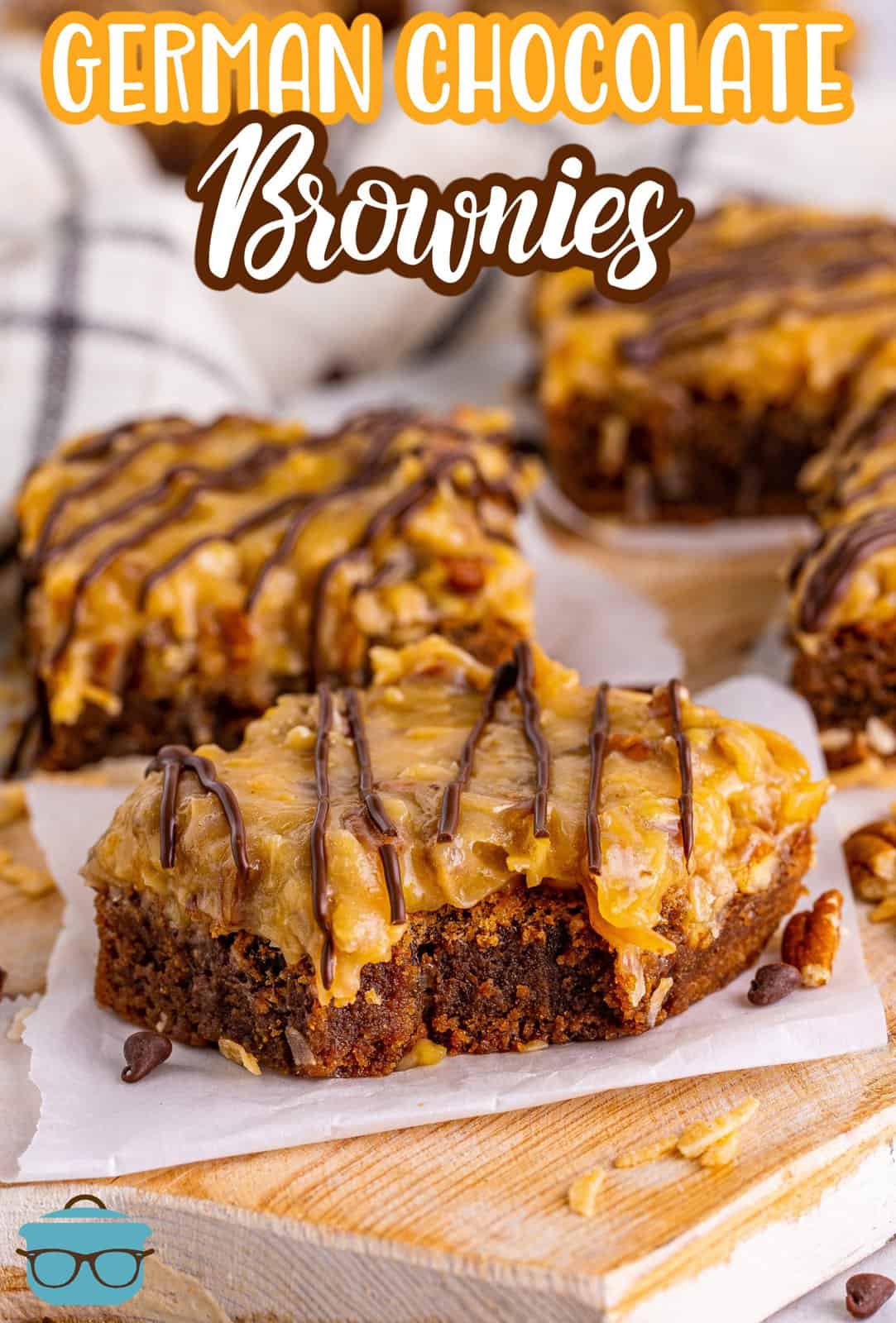 Pinterest image of German Chocolate Brownies on parchment squares with bite taken out of one.