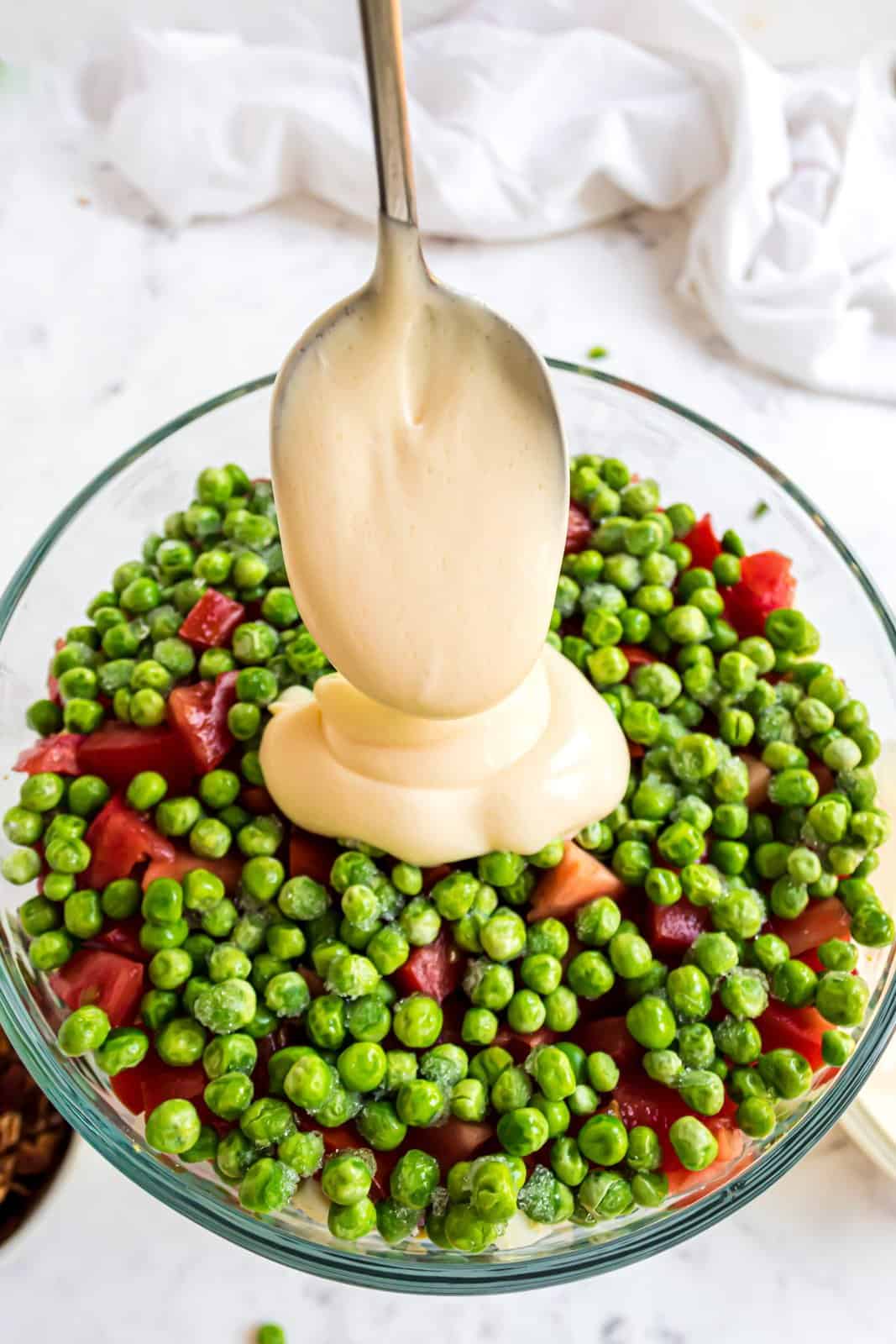 Dressing being spread over peas.